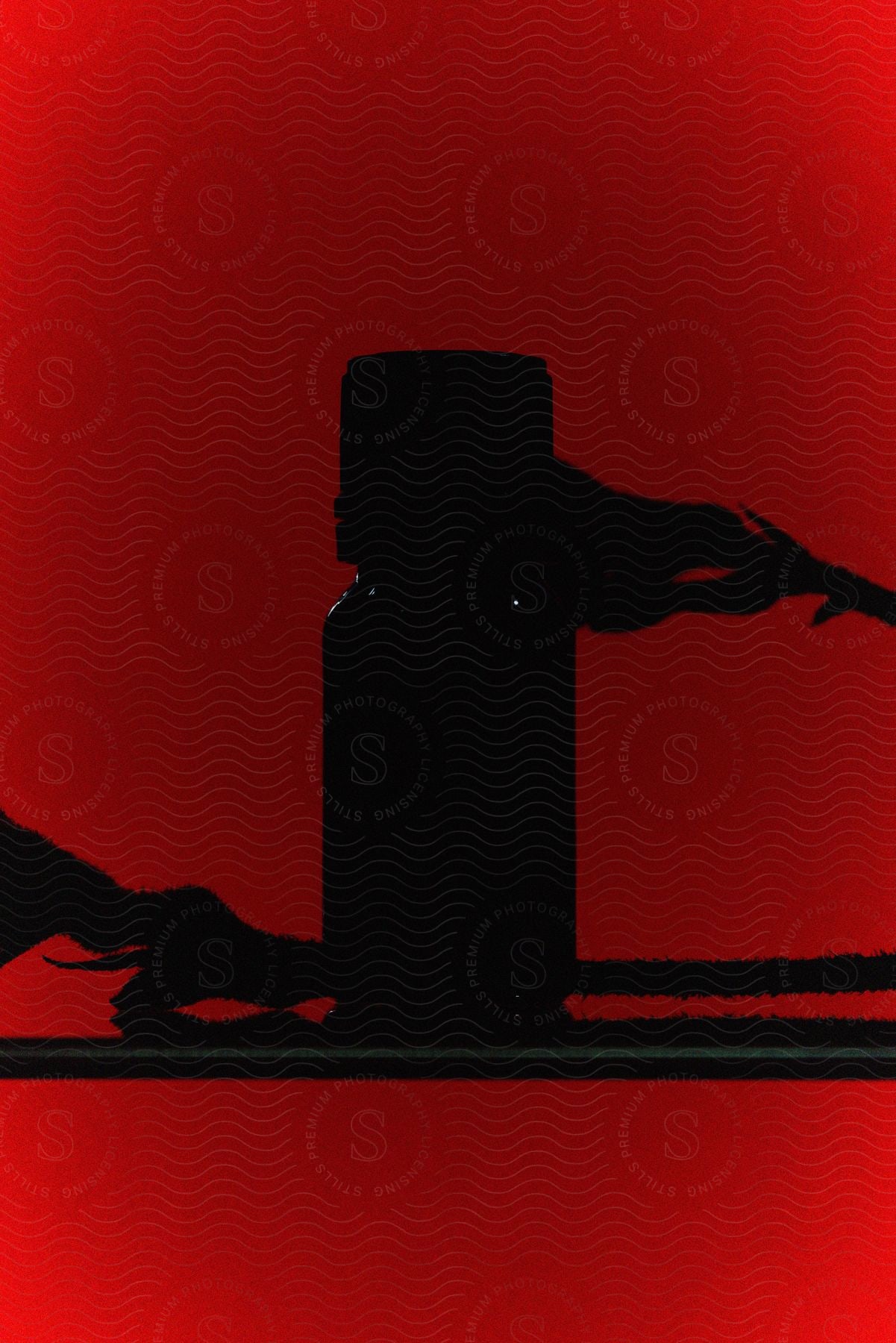 A silhouette of an object on a solid red background.