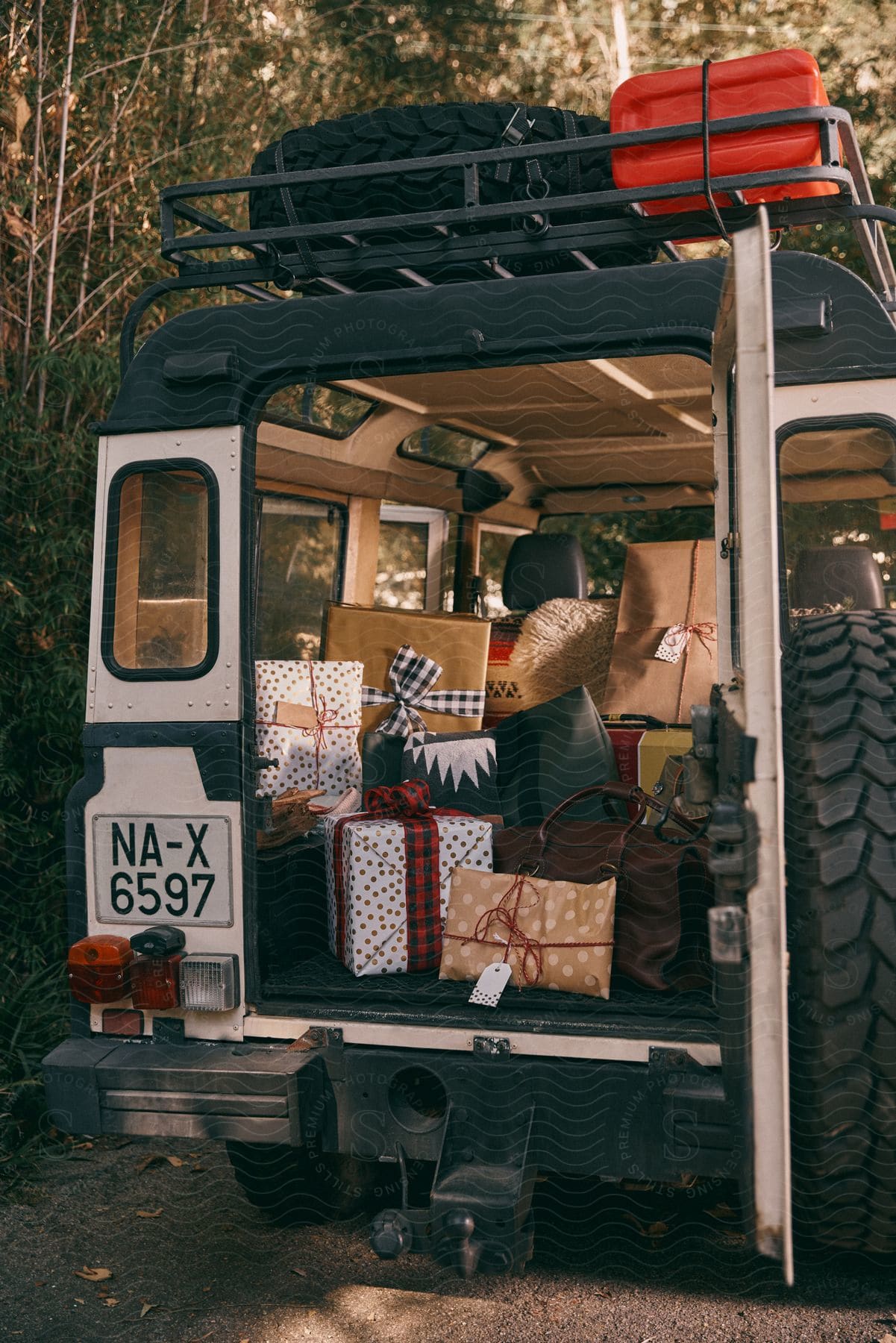 a white jeep with a roof rack filled with Christmas presents