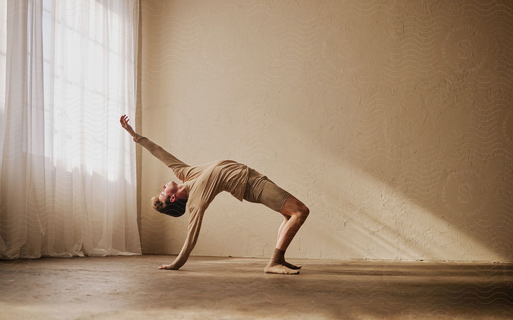 Stock photo of teenage boy dancing with one hand touching the ground.