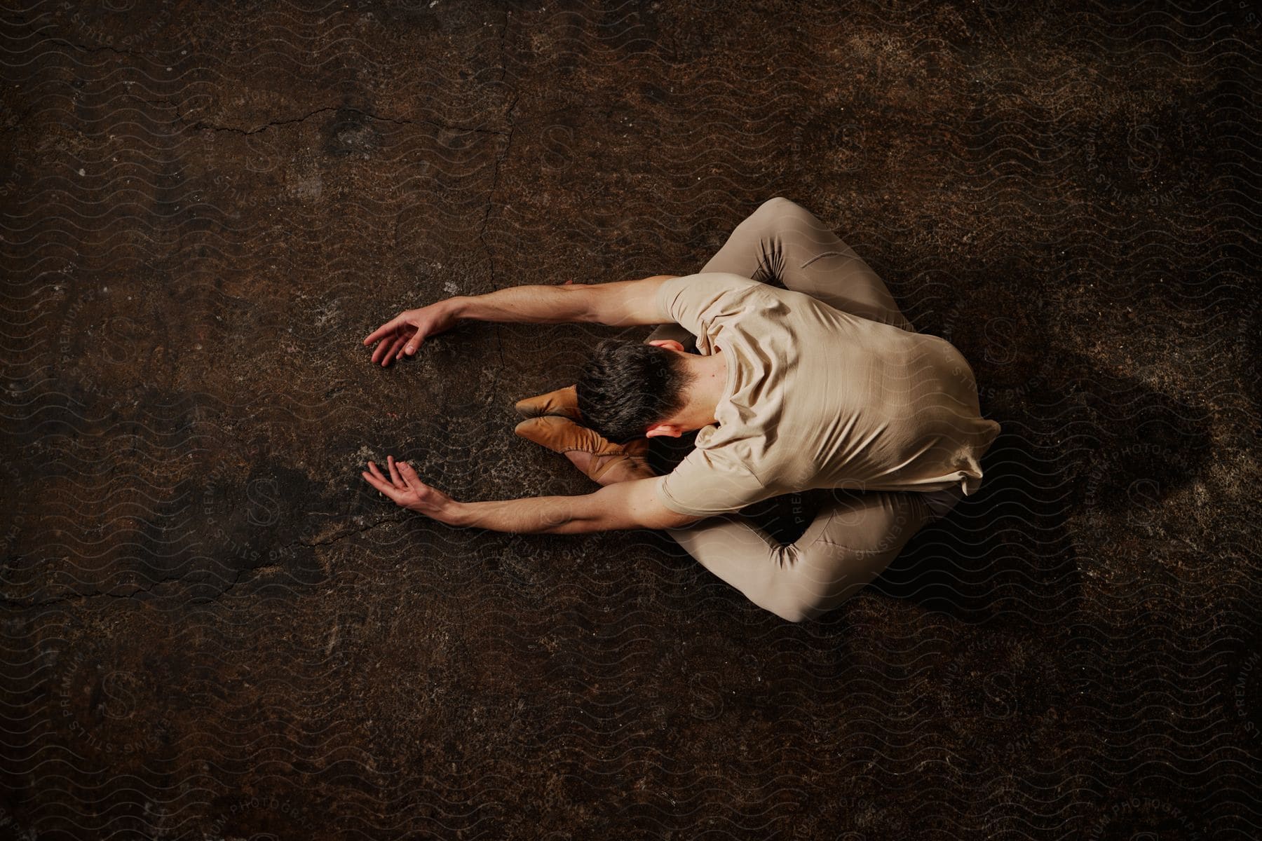 Dancer sitting on the floor and stretching.