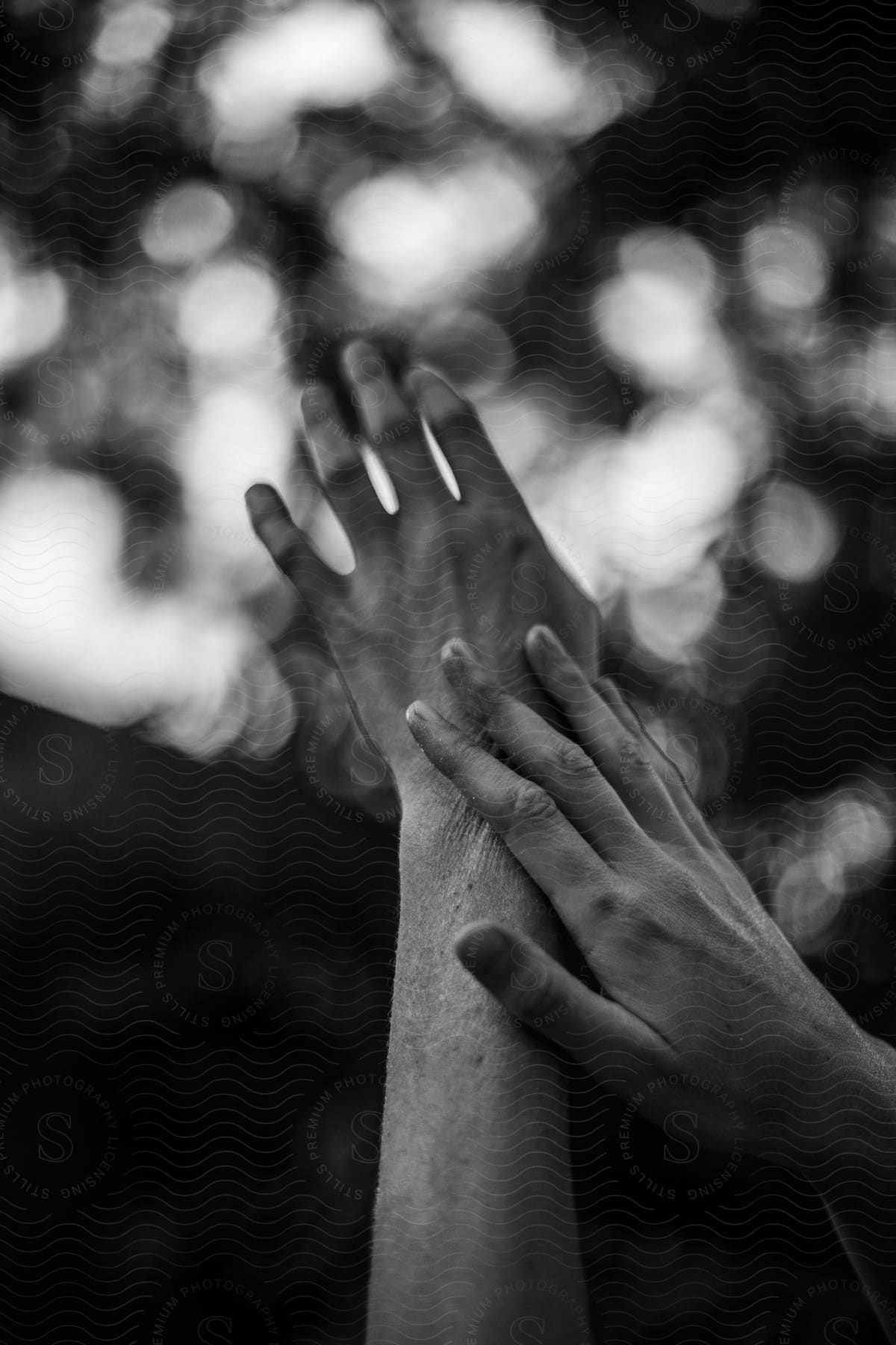 Woman strokes her arm while standing outdoors in nature.