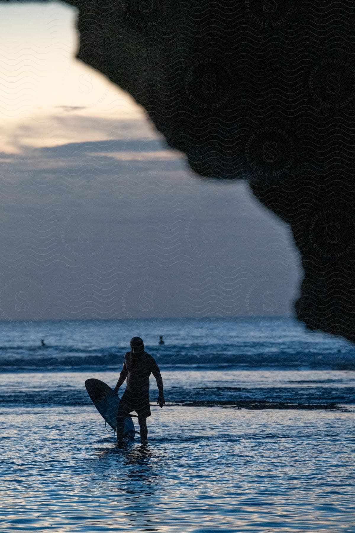 A Surfer Coming Out Of The Ocean Holding His Board