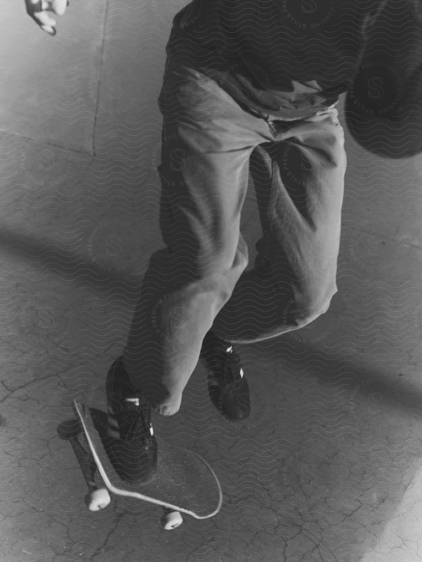 Close-up view of a man, clad in a sweater and jeans, skillfully skateboarding.