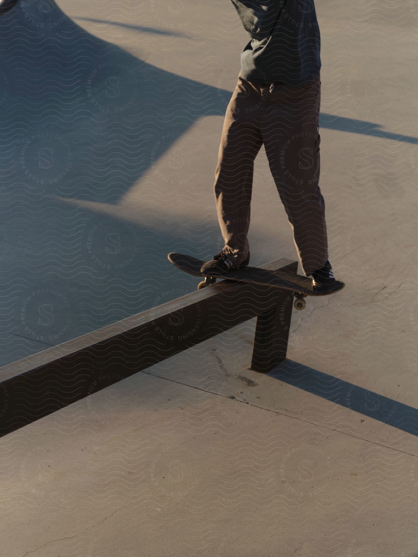 Skateboarder shreds metal rail at sunset