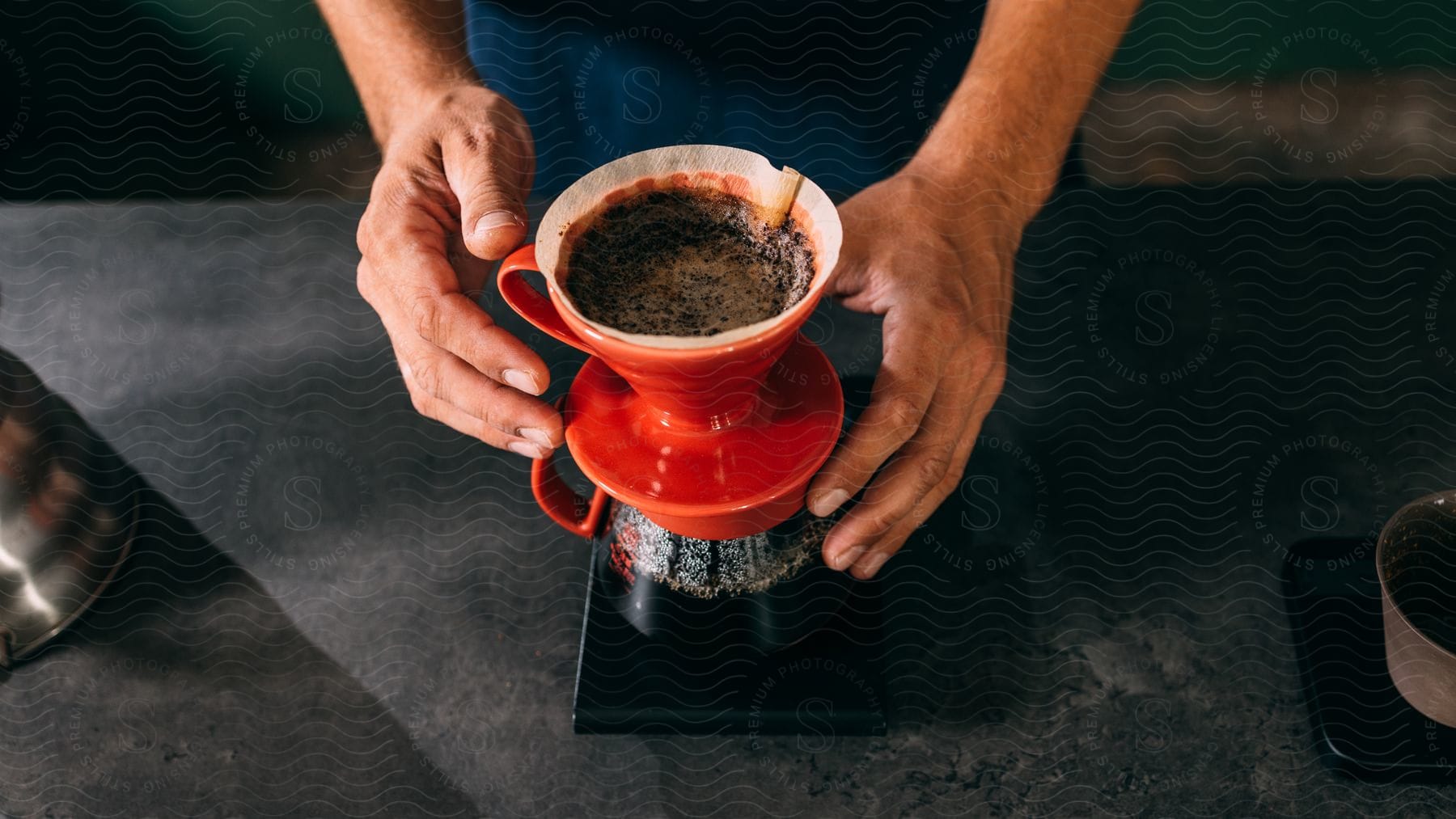 Man makes  classic pour-over coffee while standing at counter.