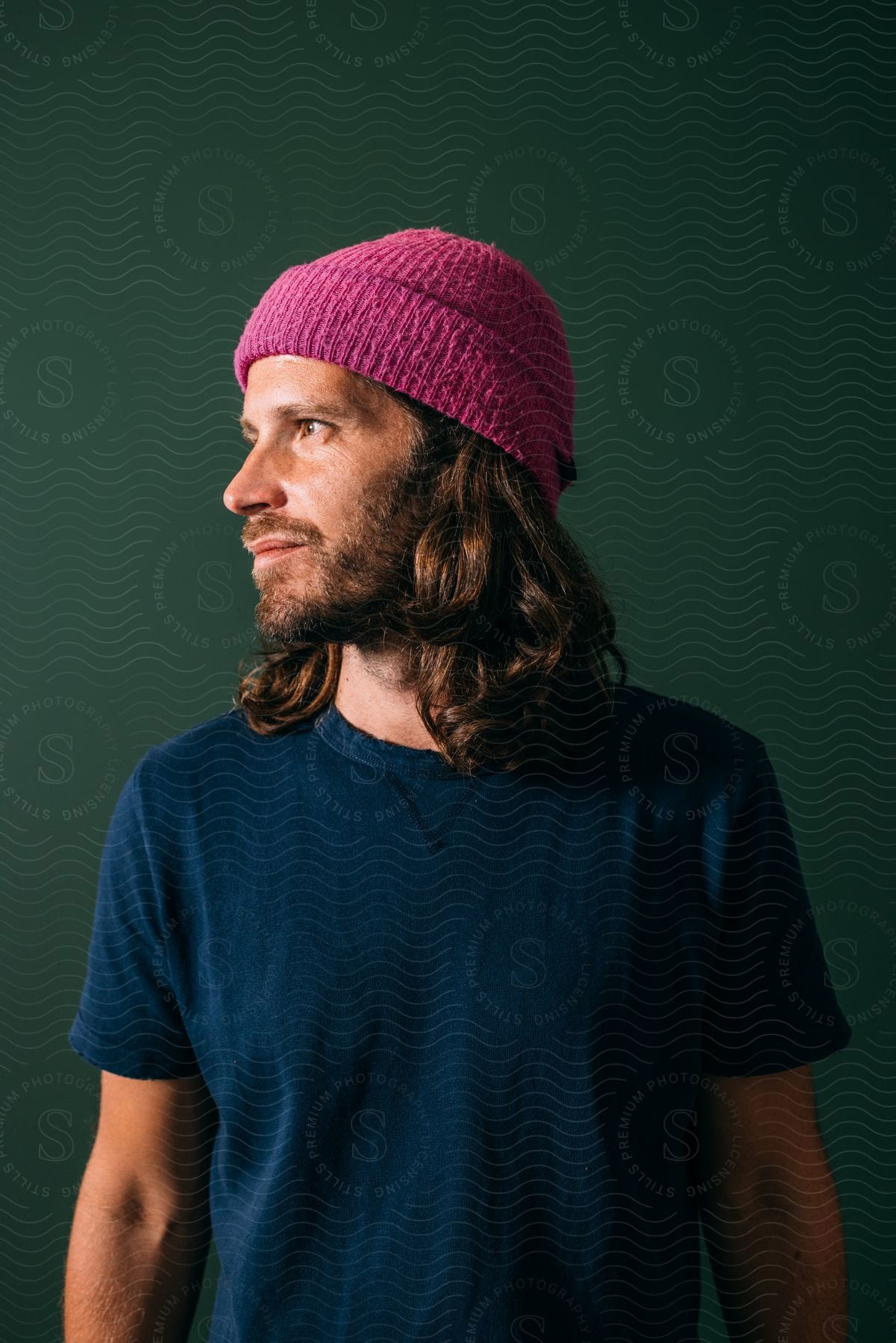 Portrait of a bearded man wearing a pink woolen hat.