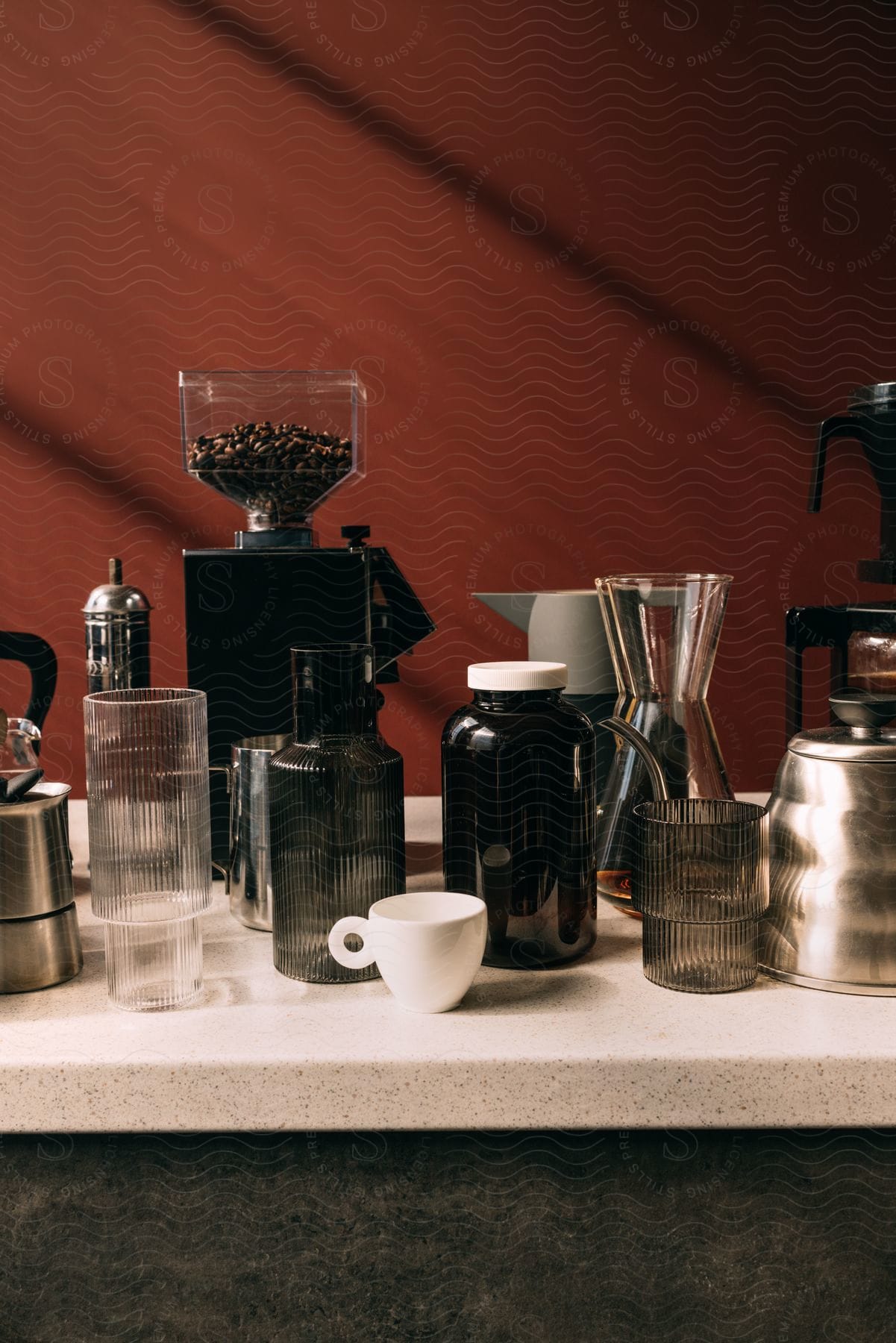 Stock photo of a coffee grinder and utensils on a bar countertop.