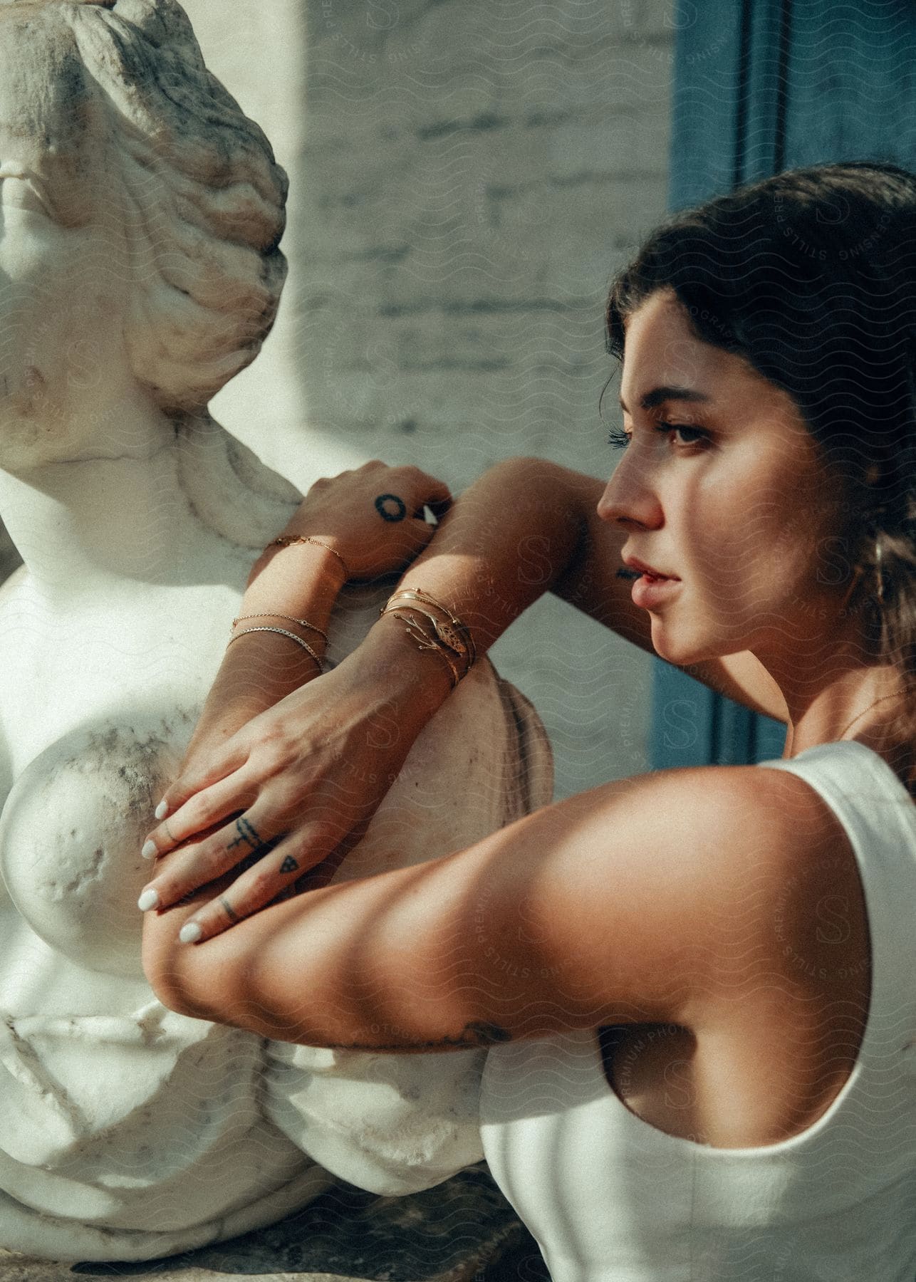 women models jewelry leaning on statue