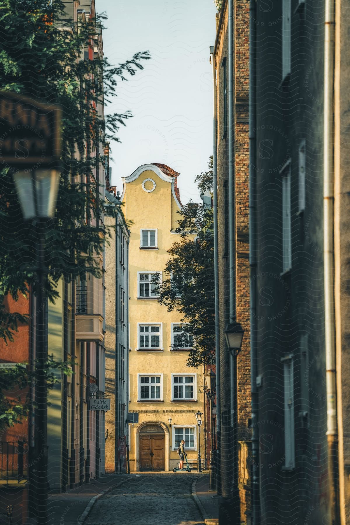 A narrow street between tall residential buildings in Gdańsk, Poland