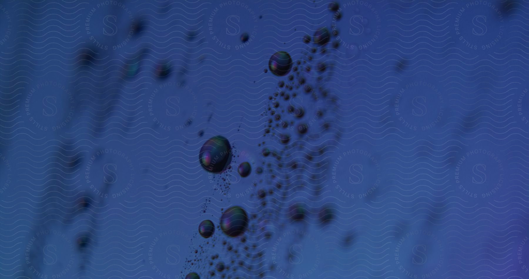 Dark orbs and spheres float over a blue surface