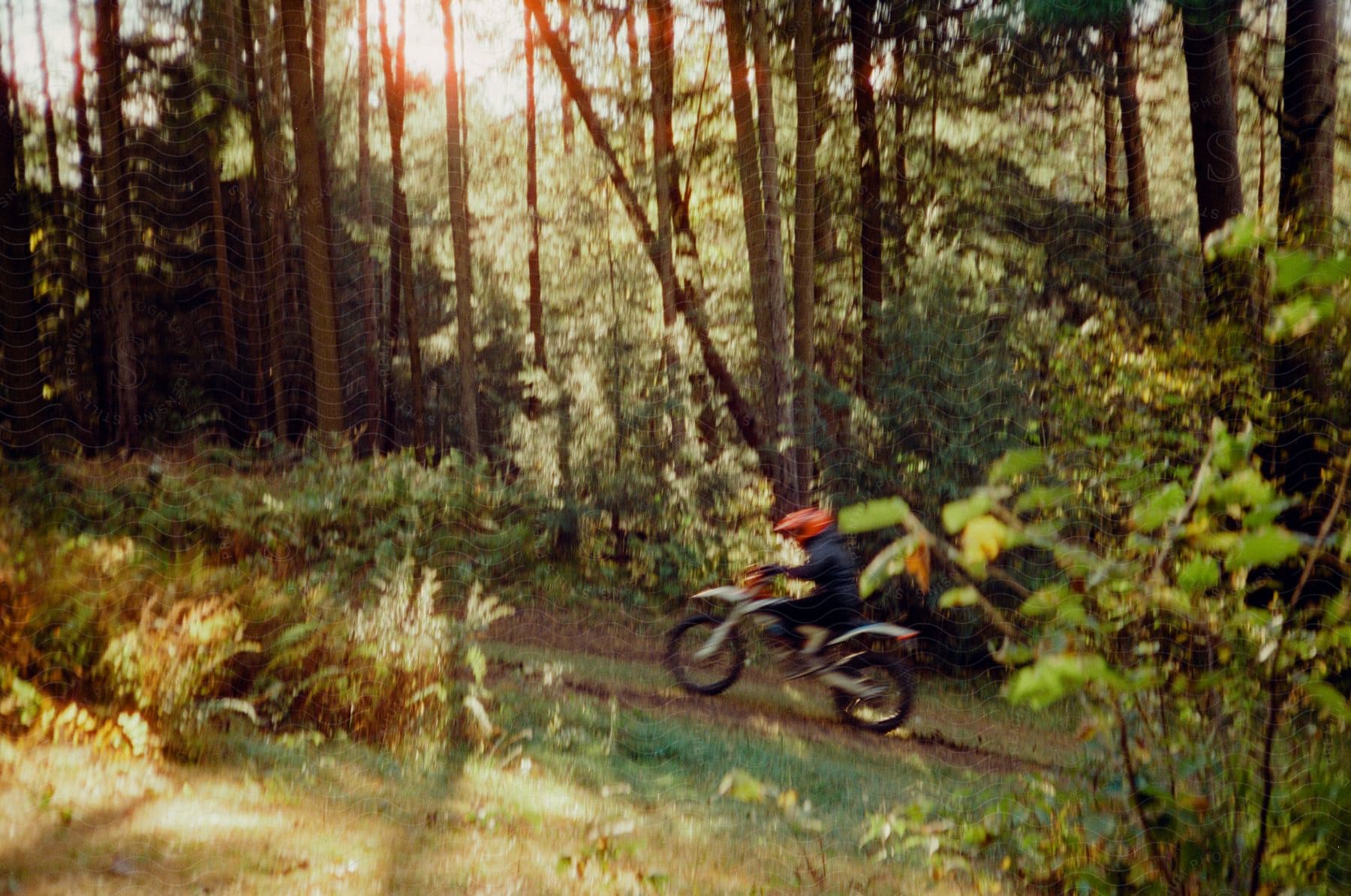 Motocross riding through a muddy track in the midst of nature.