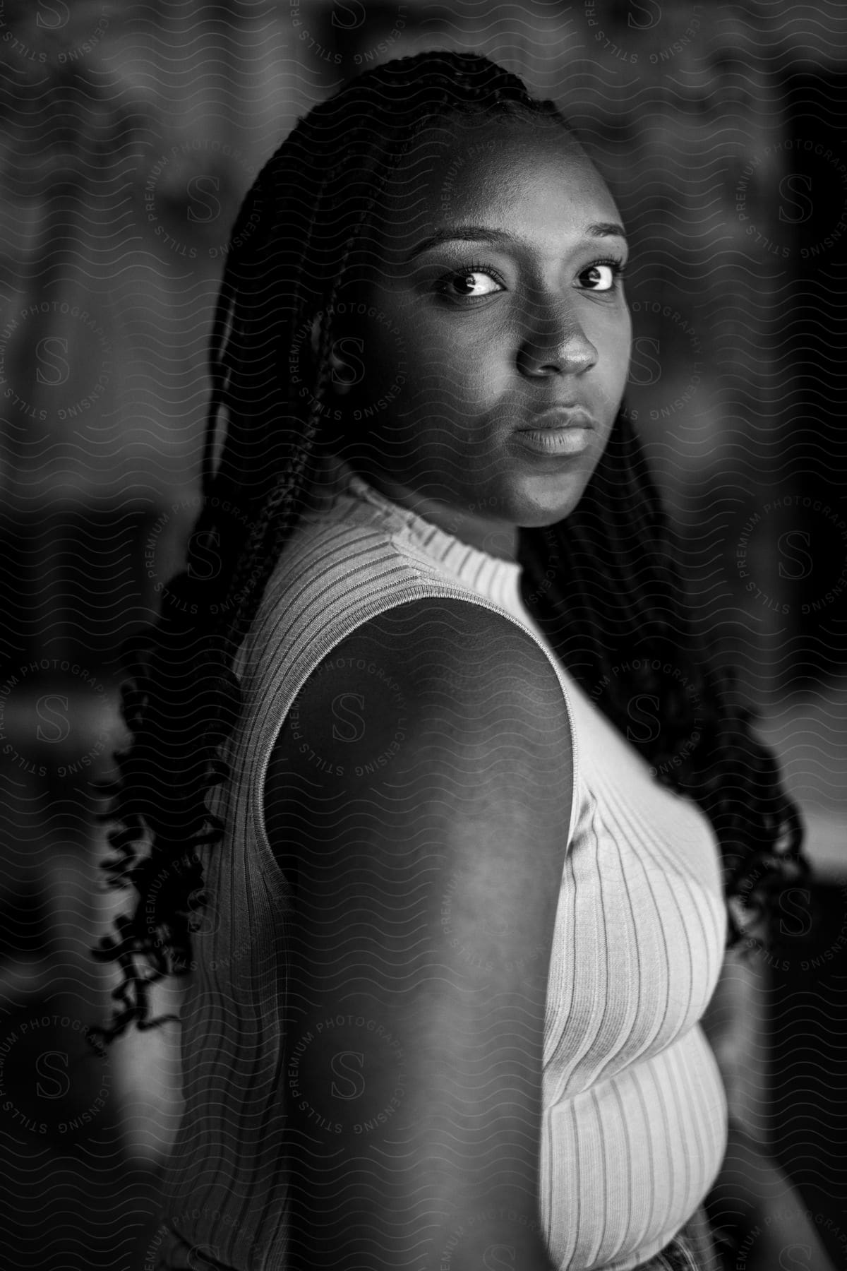 Black woman poses in profile wearing tank top