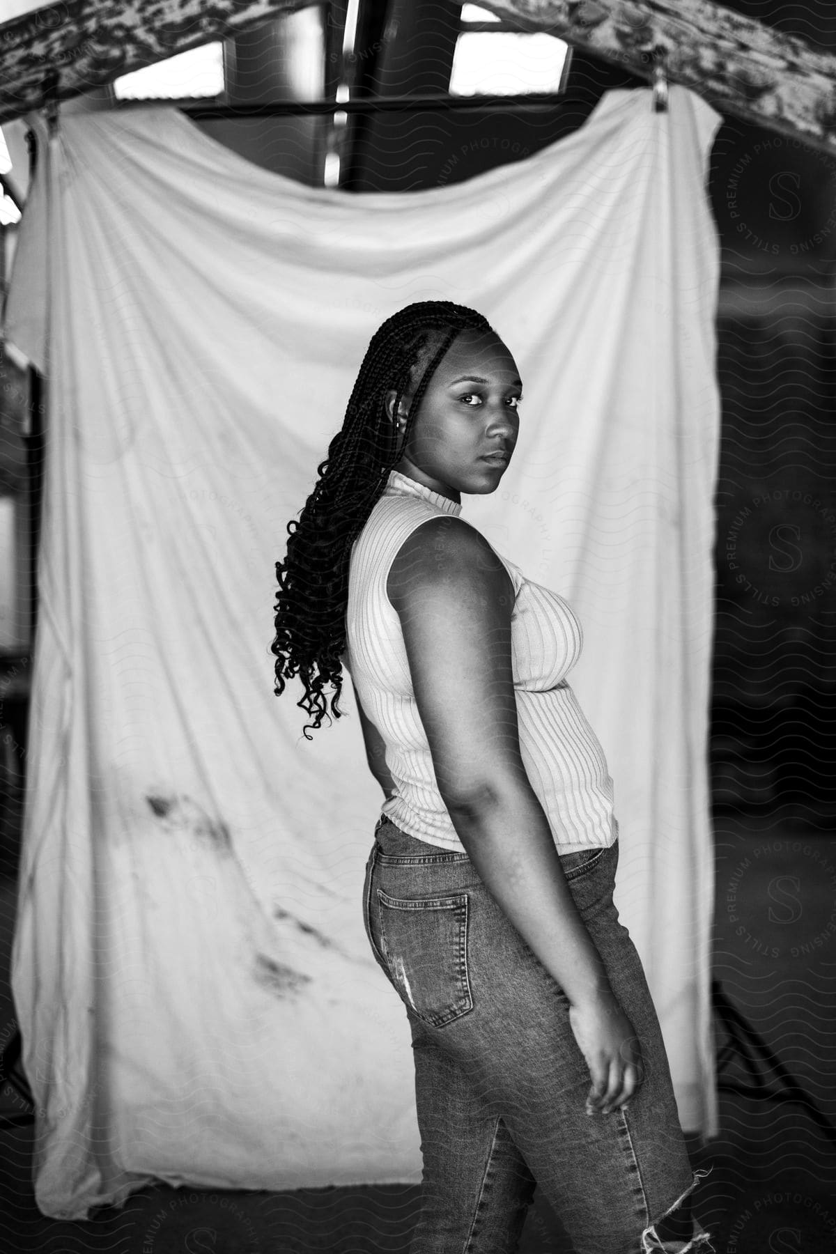 A portrait of a woman modeling clothes standing in a room.