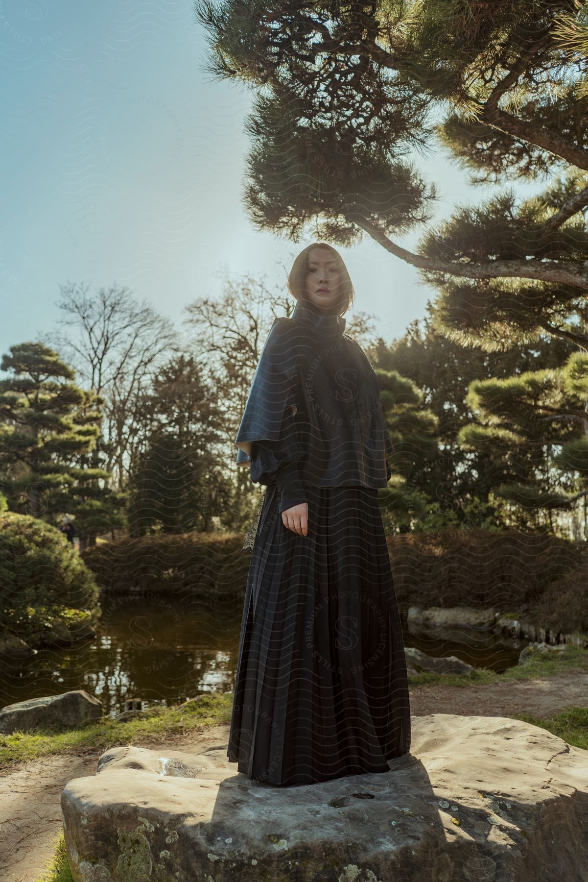 A woman modeling a dress outdoors on a sunny day.