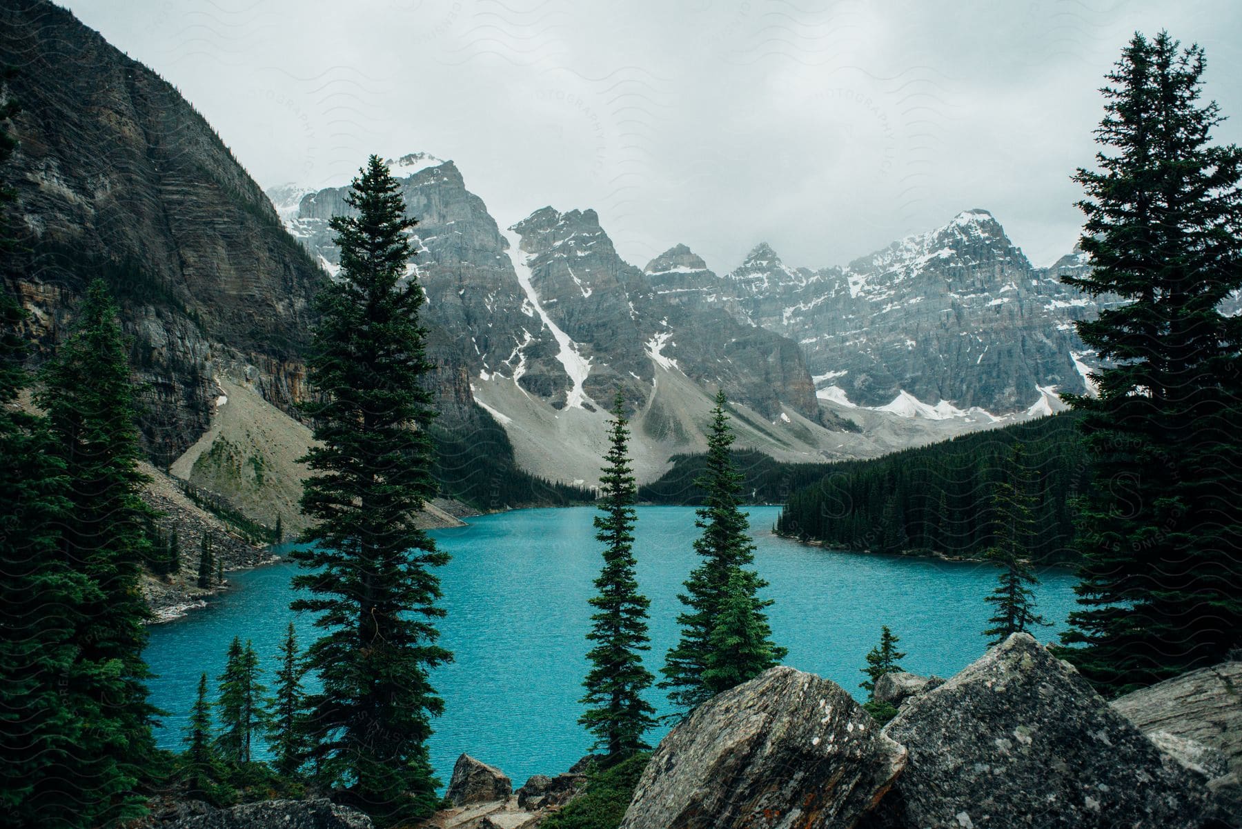 View of Moraine Lake with snow-capped mountains around.