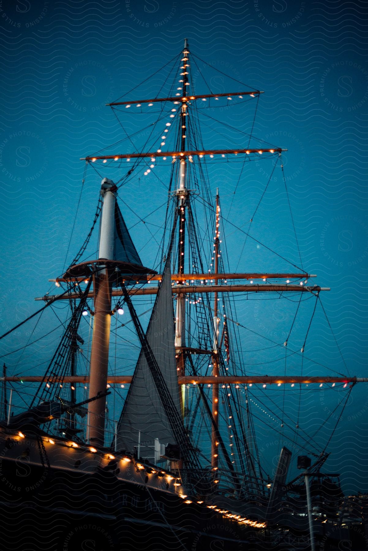 a sailing boat covered in small lights during dawn