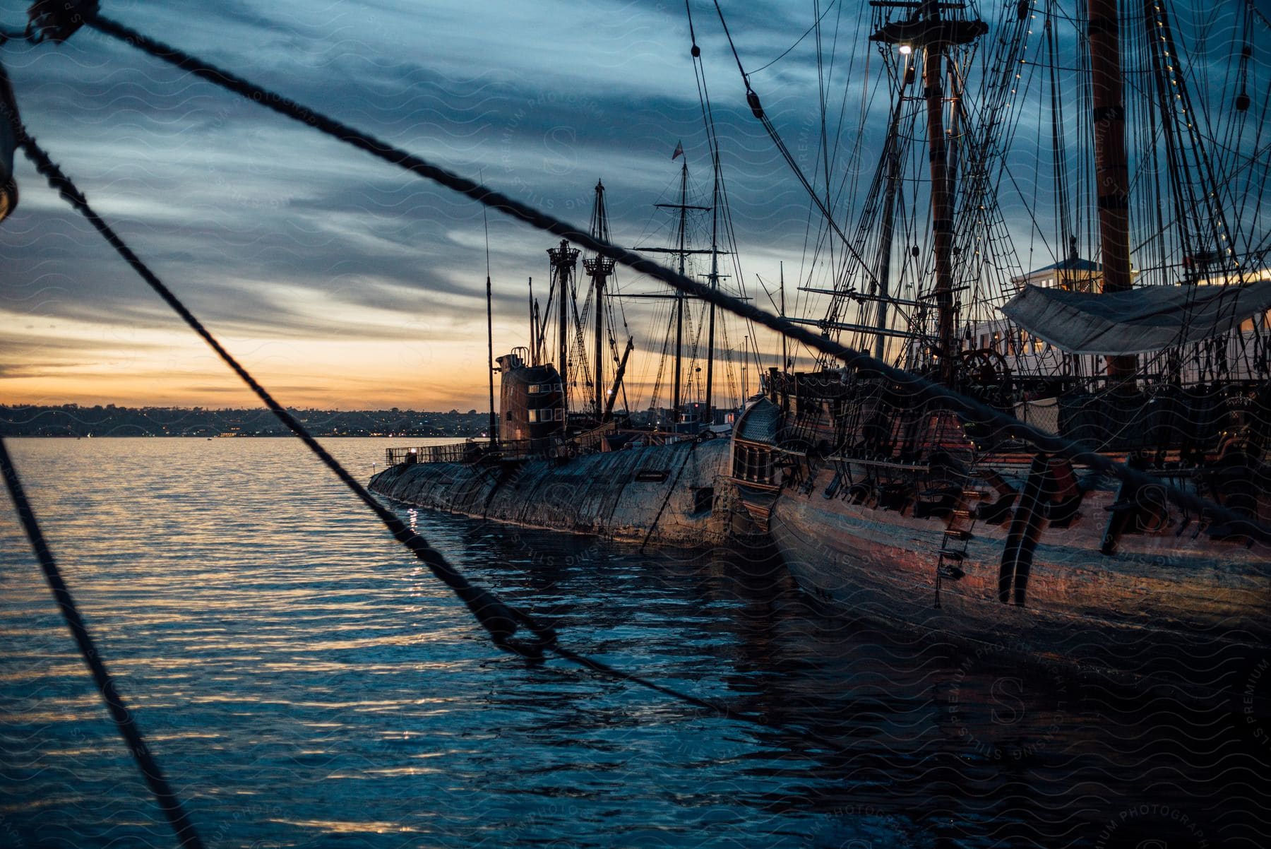 Some old wooden ships outdoors on a sunny day sitting on the water.