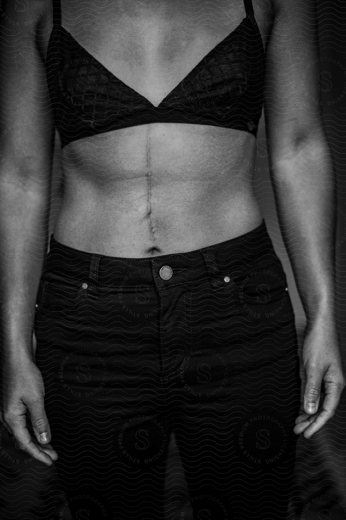 Female torso wearing black bralet and black jeans