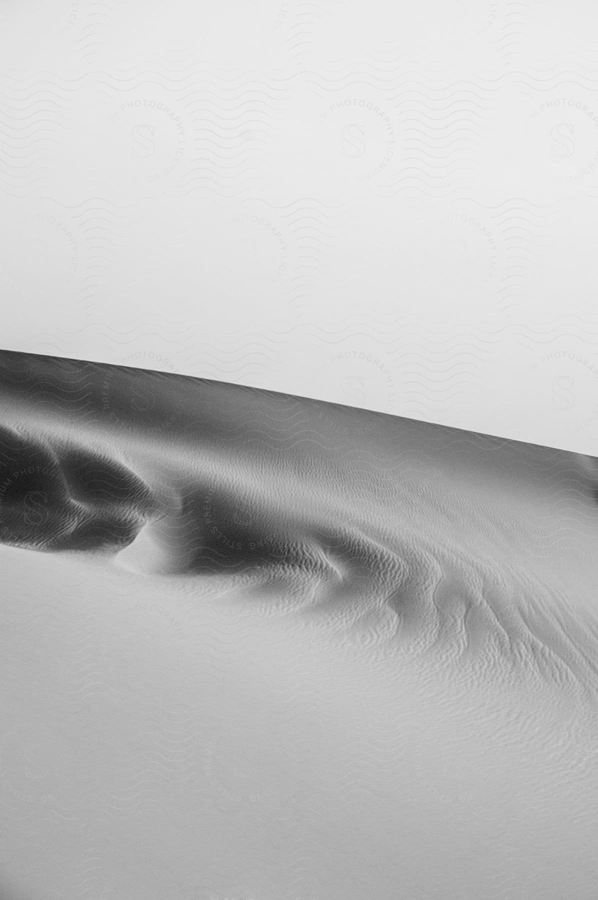 An abstract of a sand dune with ripples and waves below a ridge