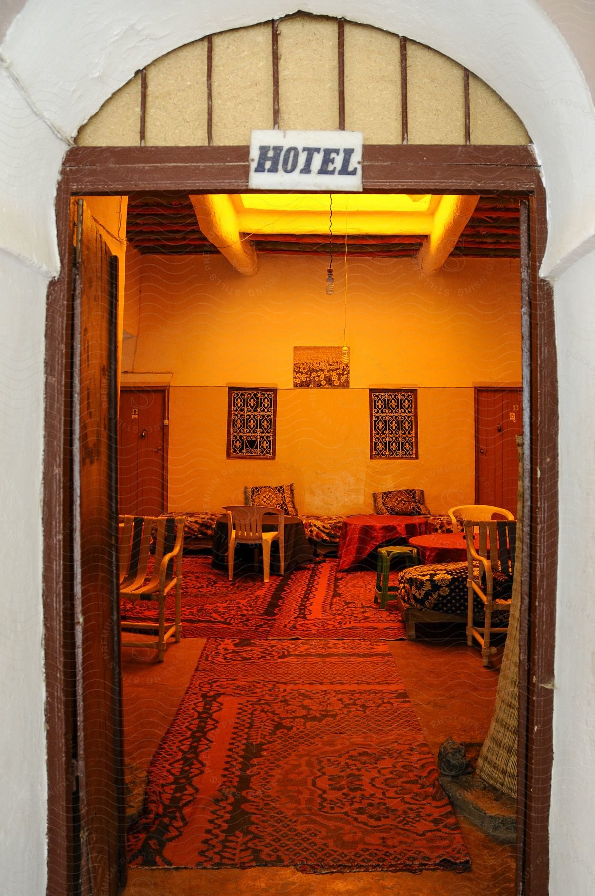 A hotel entrance with red lights and old decor.