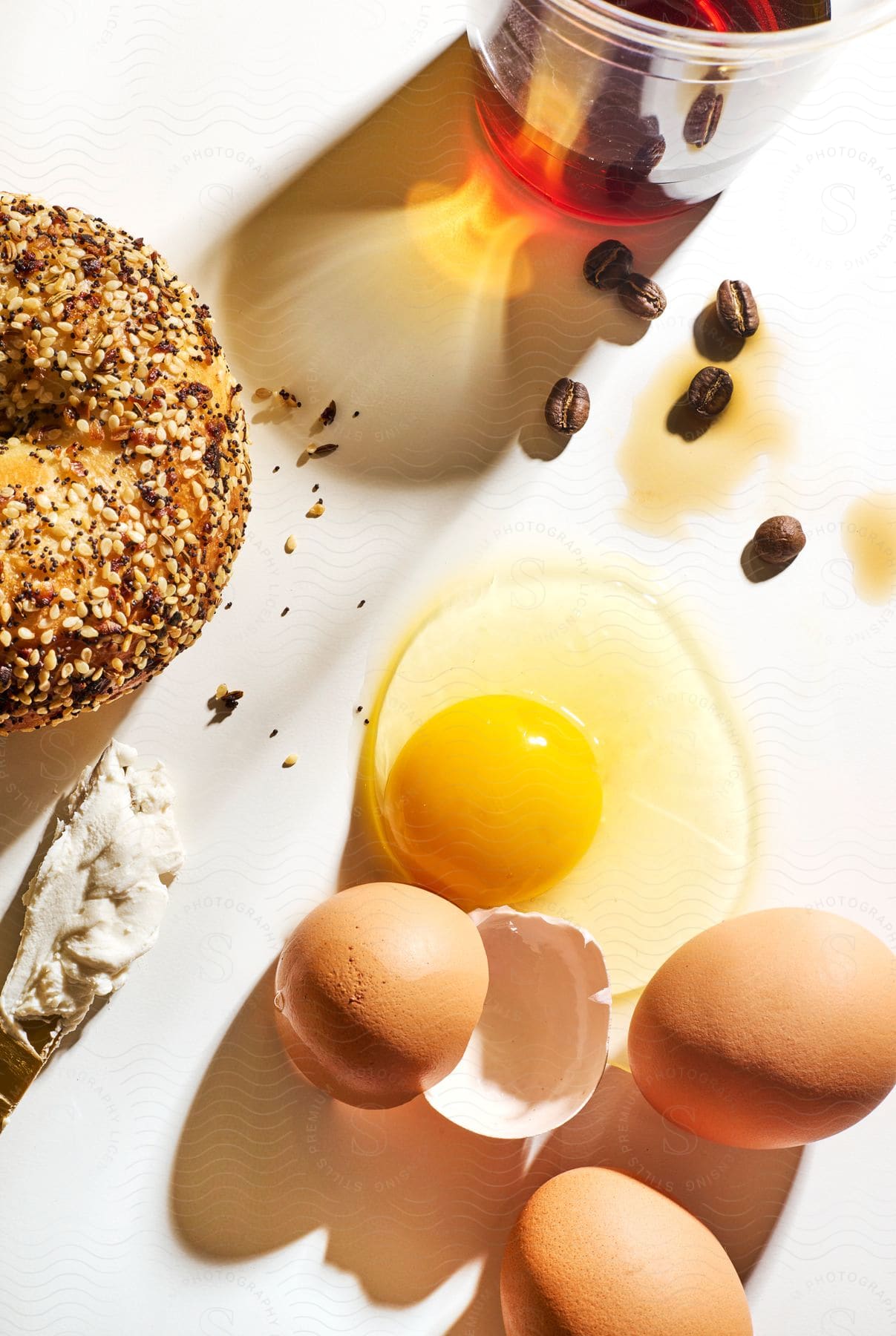 a bagel, eggs, cream cheese, and coffee on a wooden table