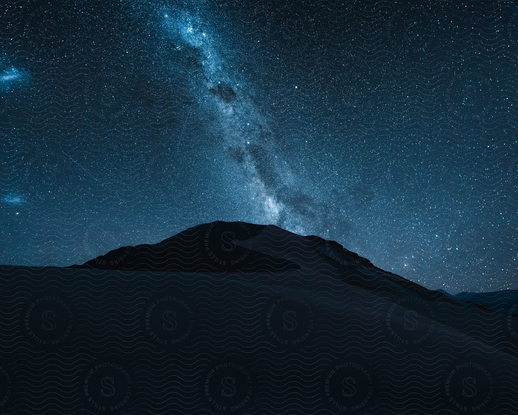 A hill of sand in the desert and a starry sky.