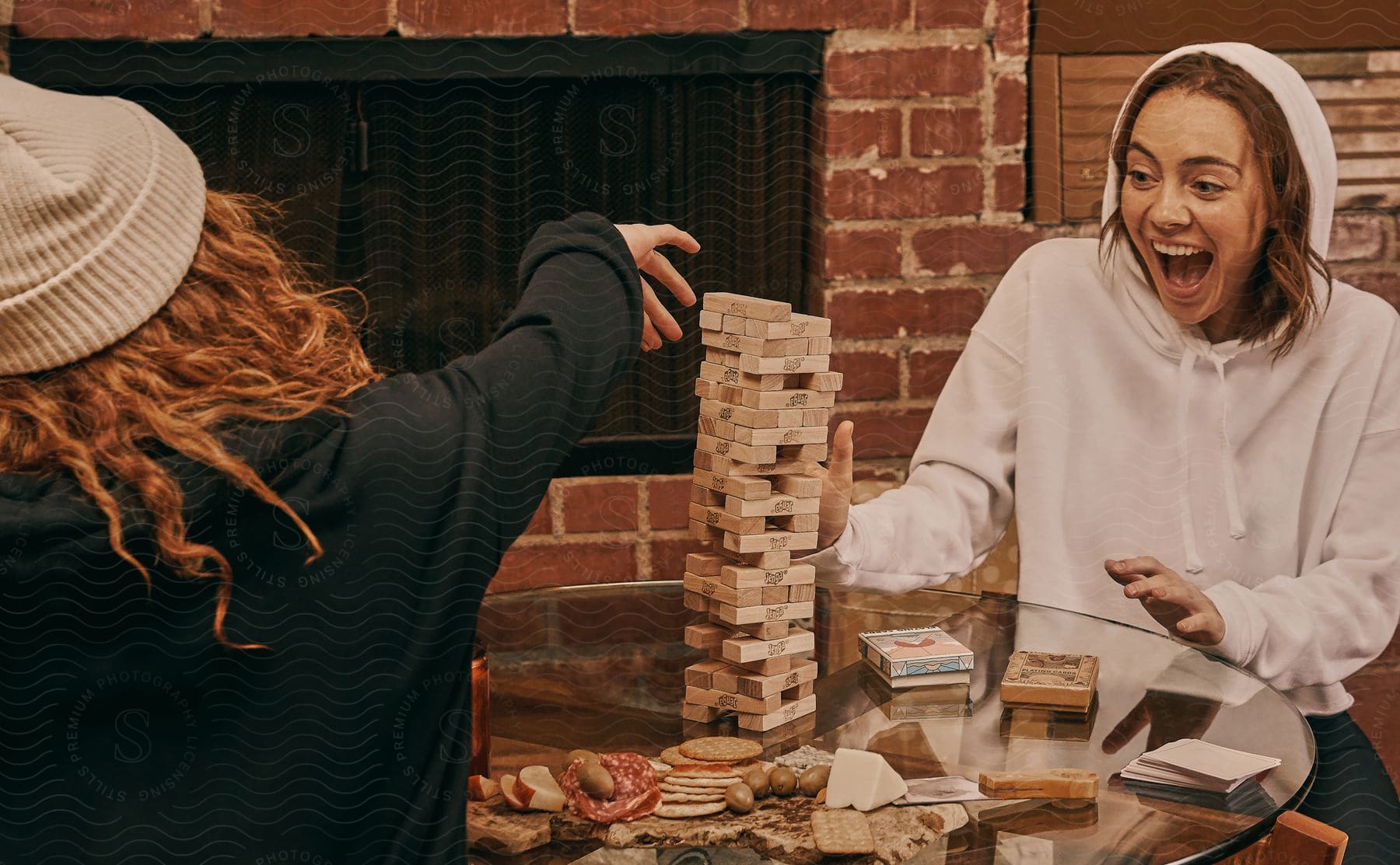 Women playing Jenga are excited and laughing