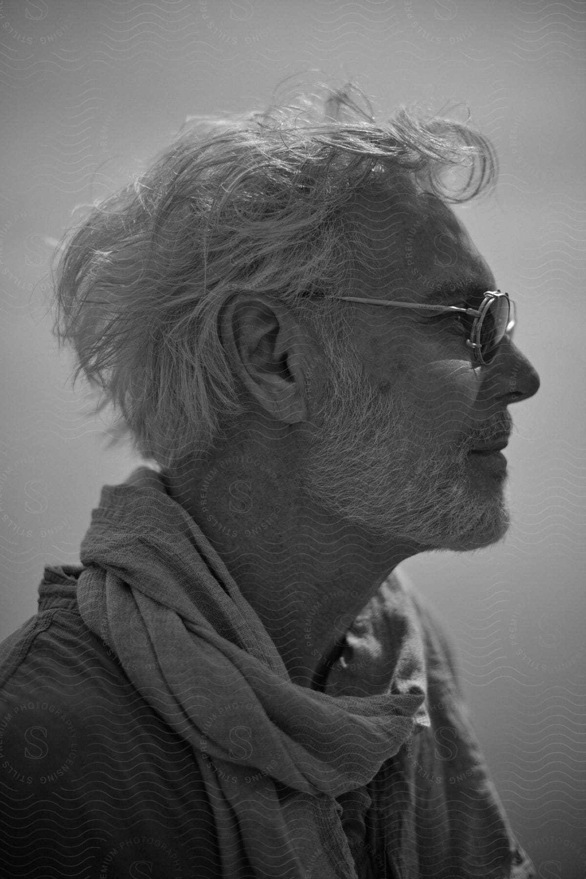 Close up profile of older man standing outdoors.