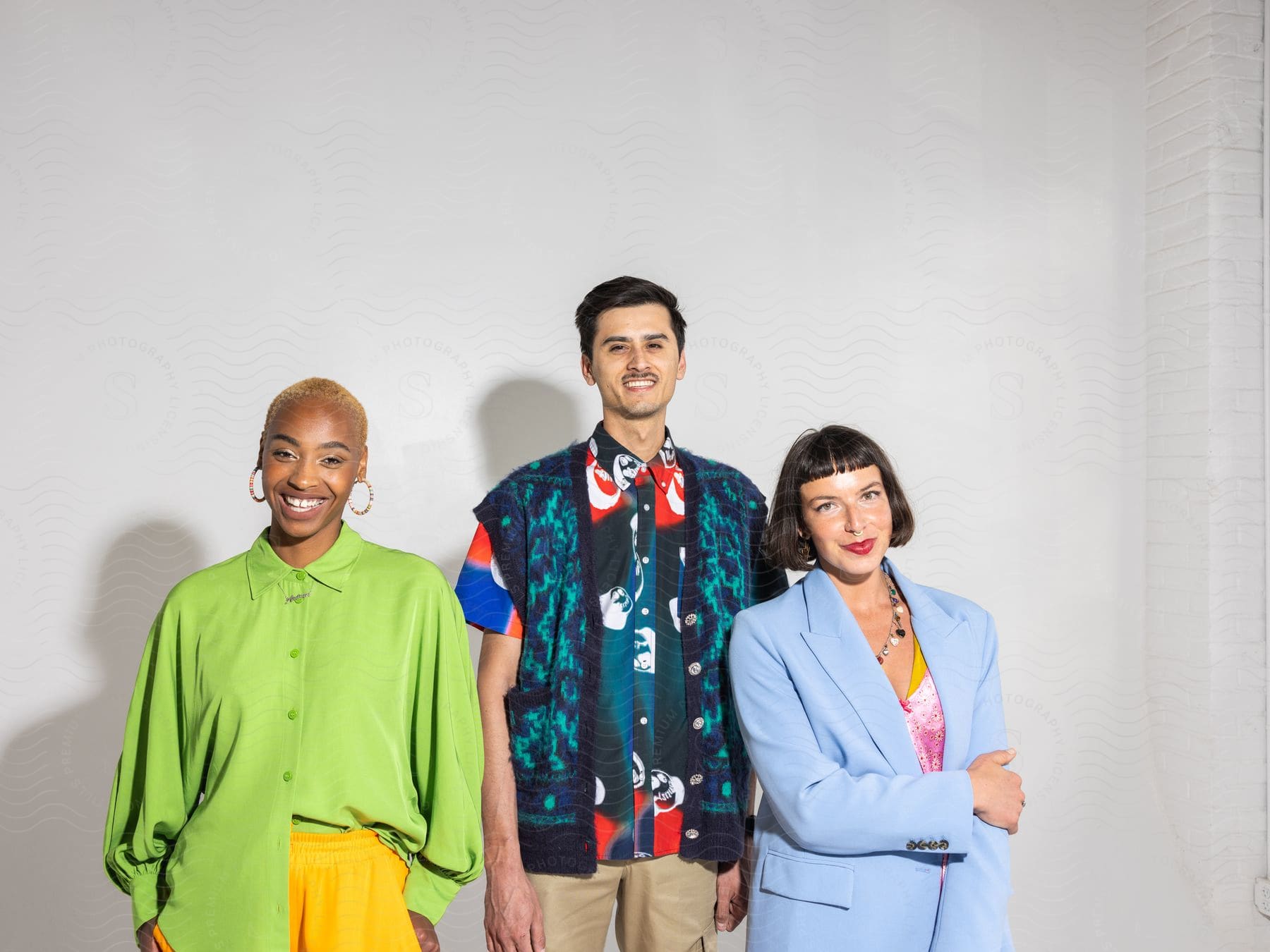 Three brightly clothed people smiling in a group.