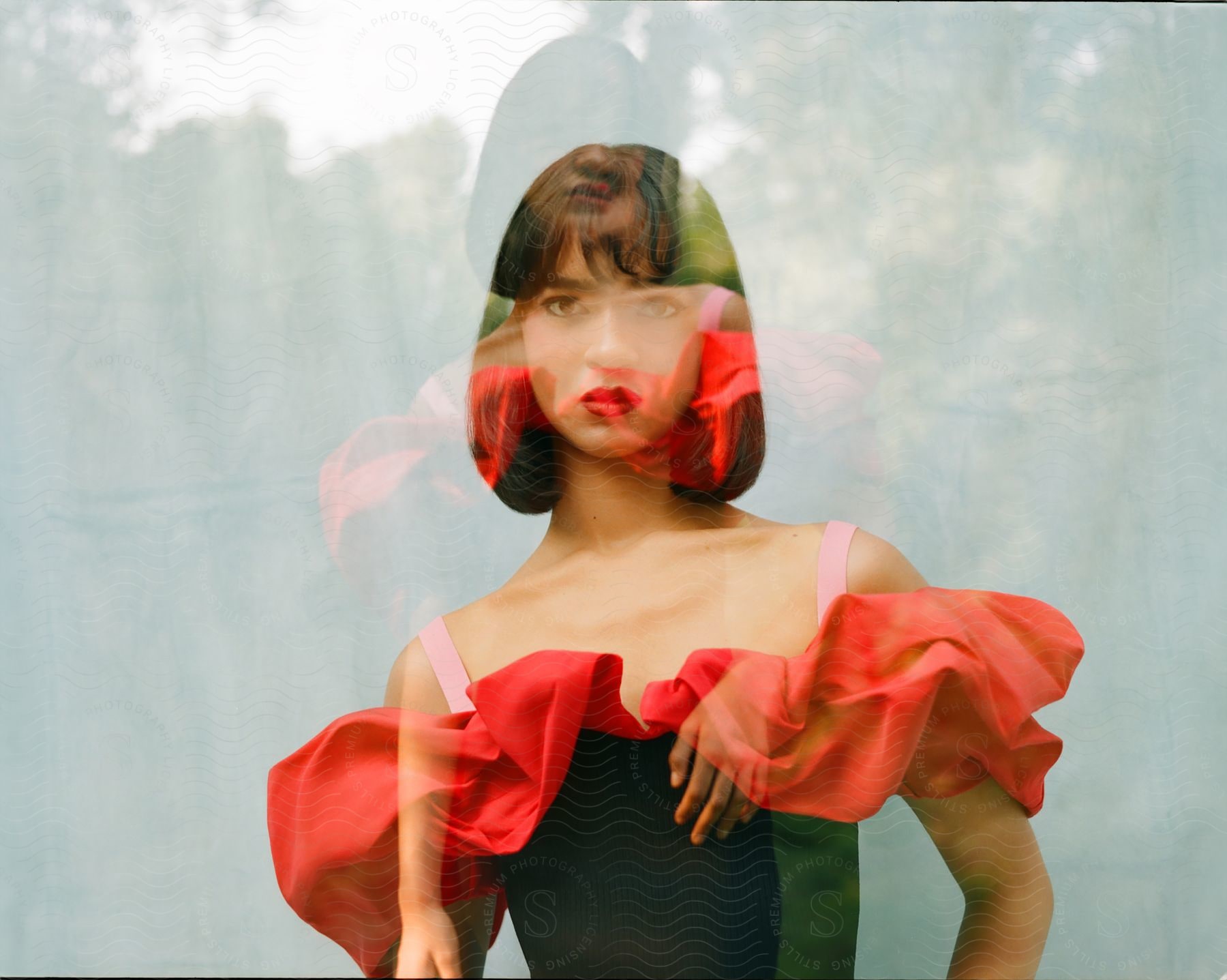 Double exposure of an Asian woman in a black dress with red ruff and pink shoulder straps.