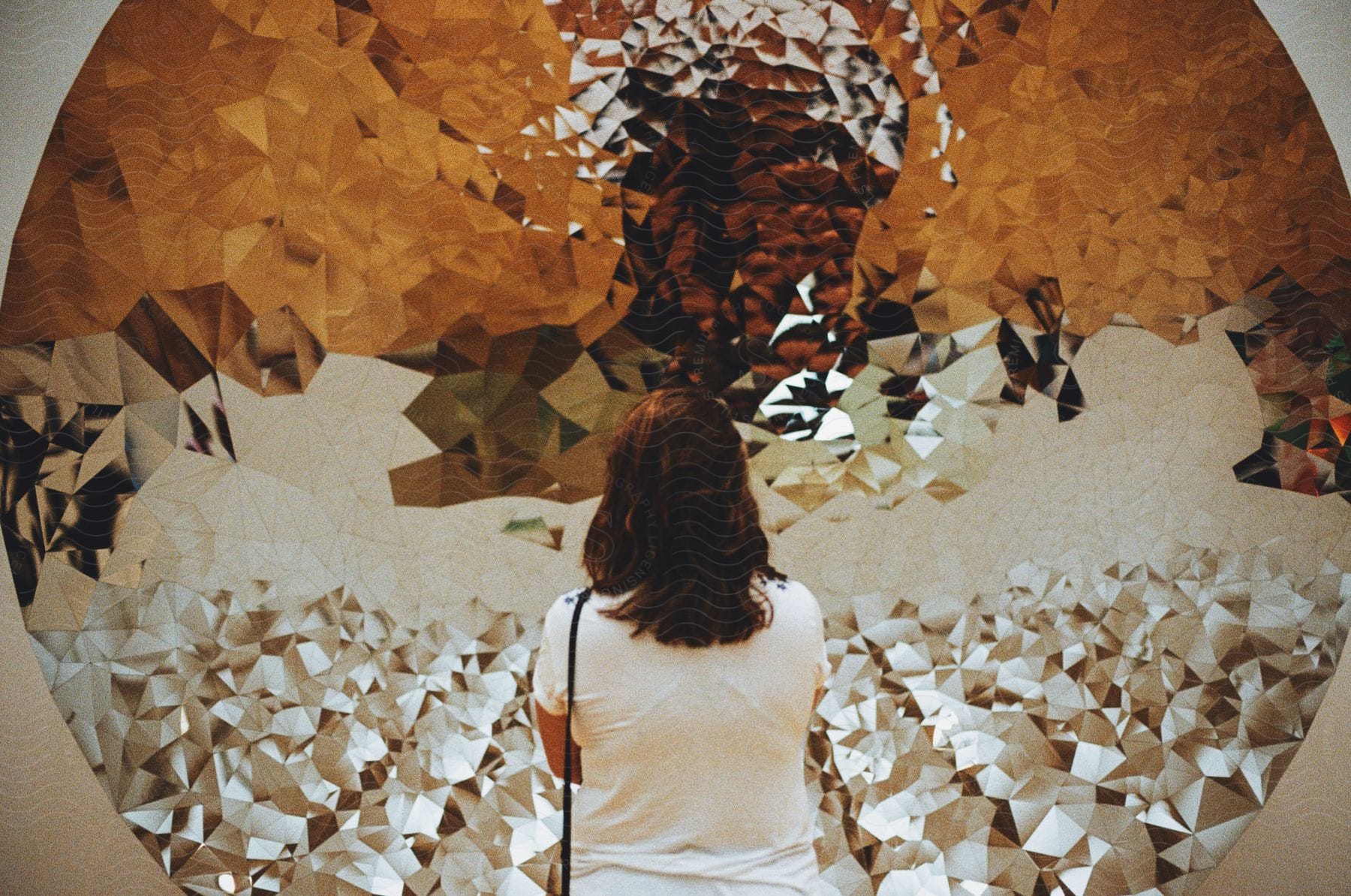 woman stands facing textural  interior art installation