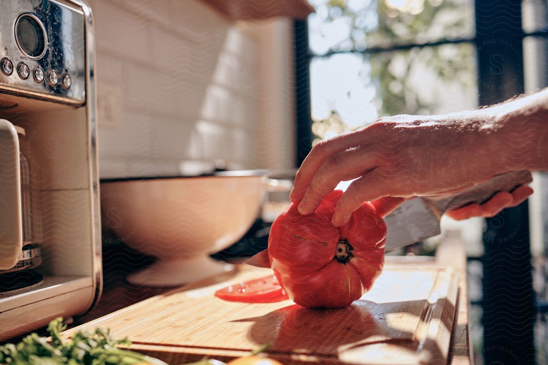 Man slices tomatoes on a chopping board in the kitchen