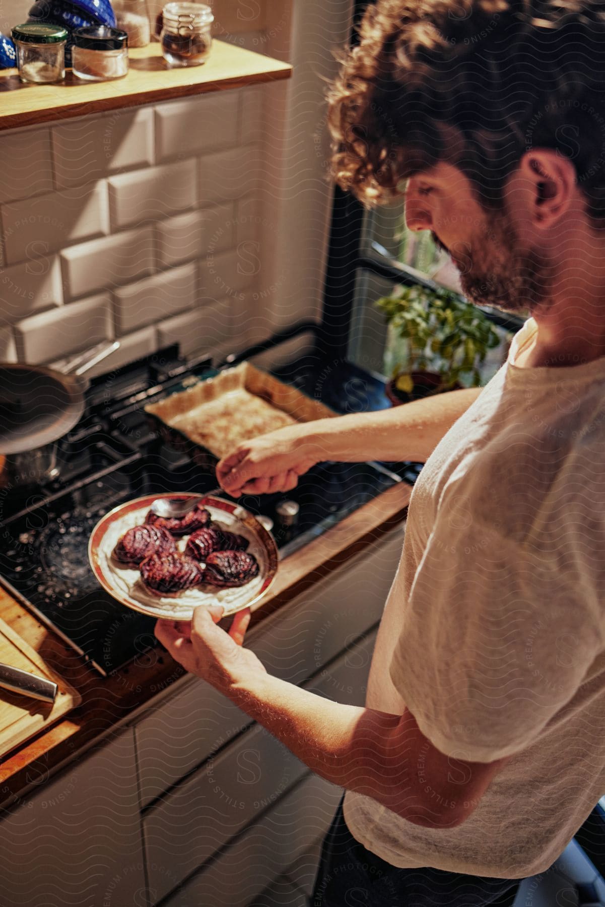 Stock photo of a man spoons au jus on plated steaks