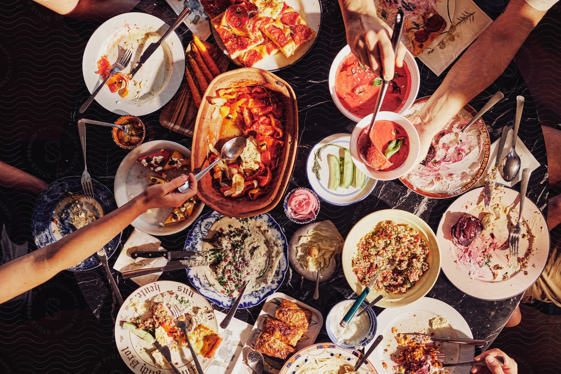 People share meal at table with several different prepared dishes.