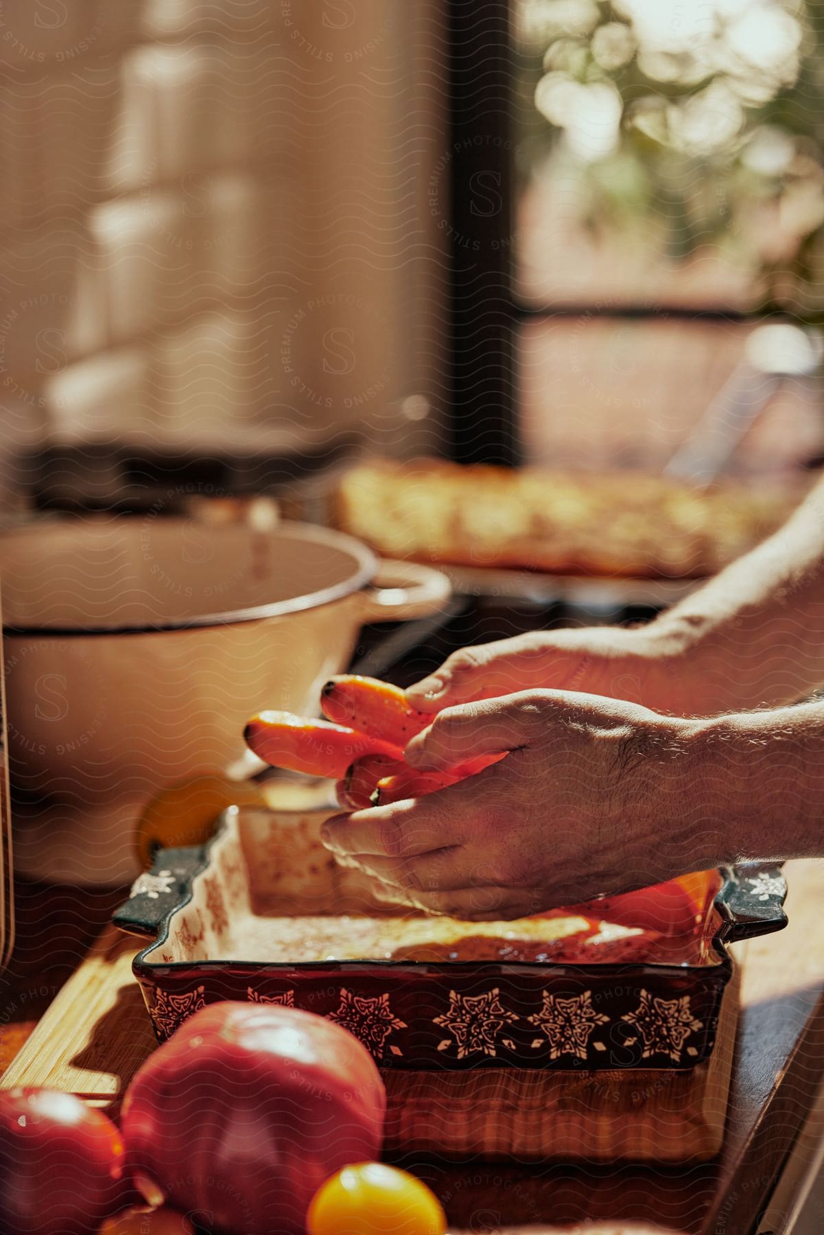 Man cooks with carrots in kitchen.