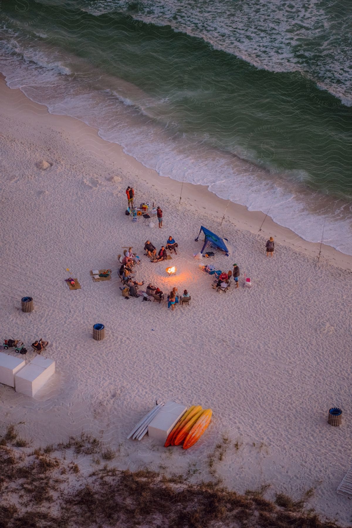 Skyline of a group of people at a bonfire on the beach.