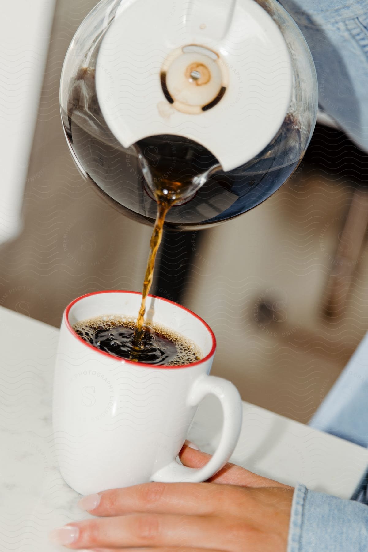 Someone pouring themselves a large cup of coffee.