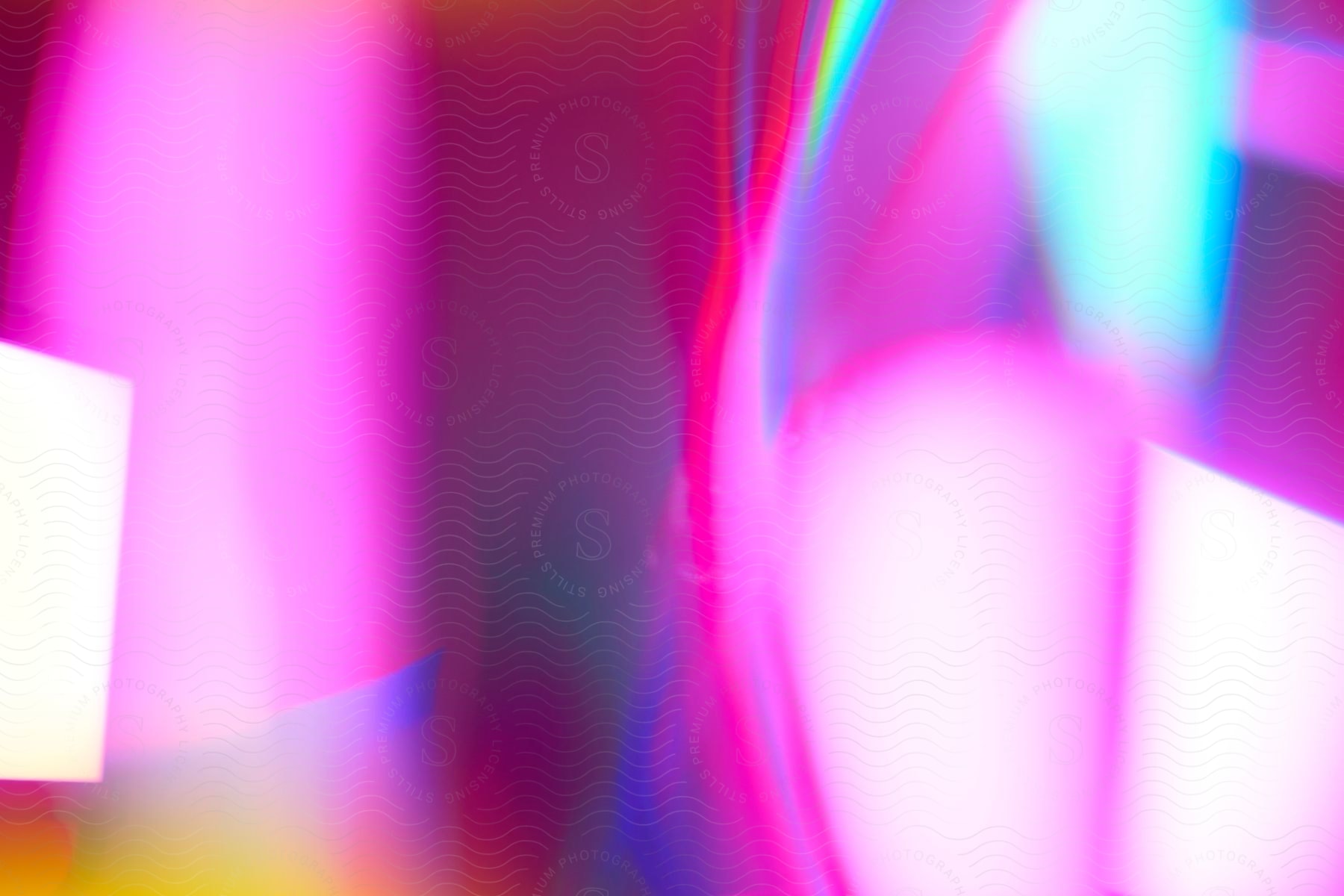 A blurry and abstract image with a combination of pink, blue, and white lights.