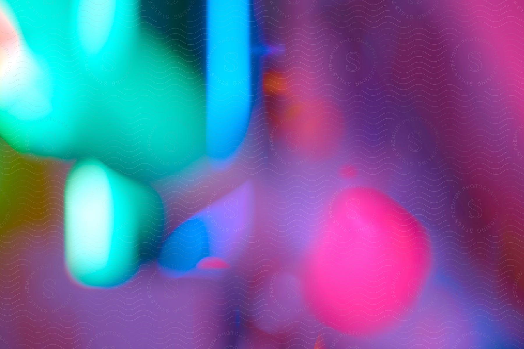 close-up abstract photograph with a soft focus featuring a blend of bright vibrant colors with dominant tones of green, blue, and pink.