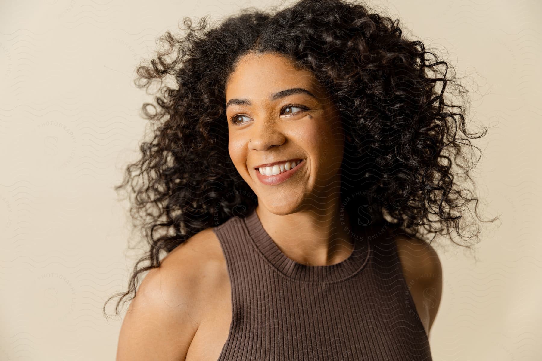 Portrait of a smiling woman with curly hair modeling.