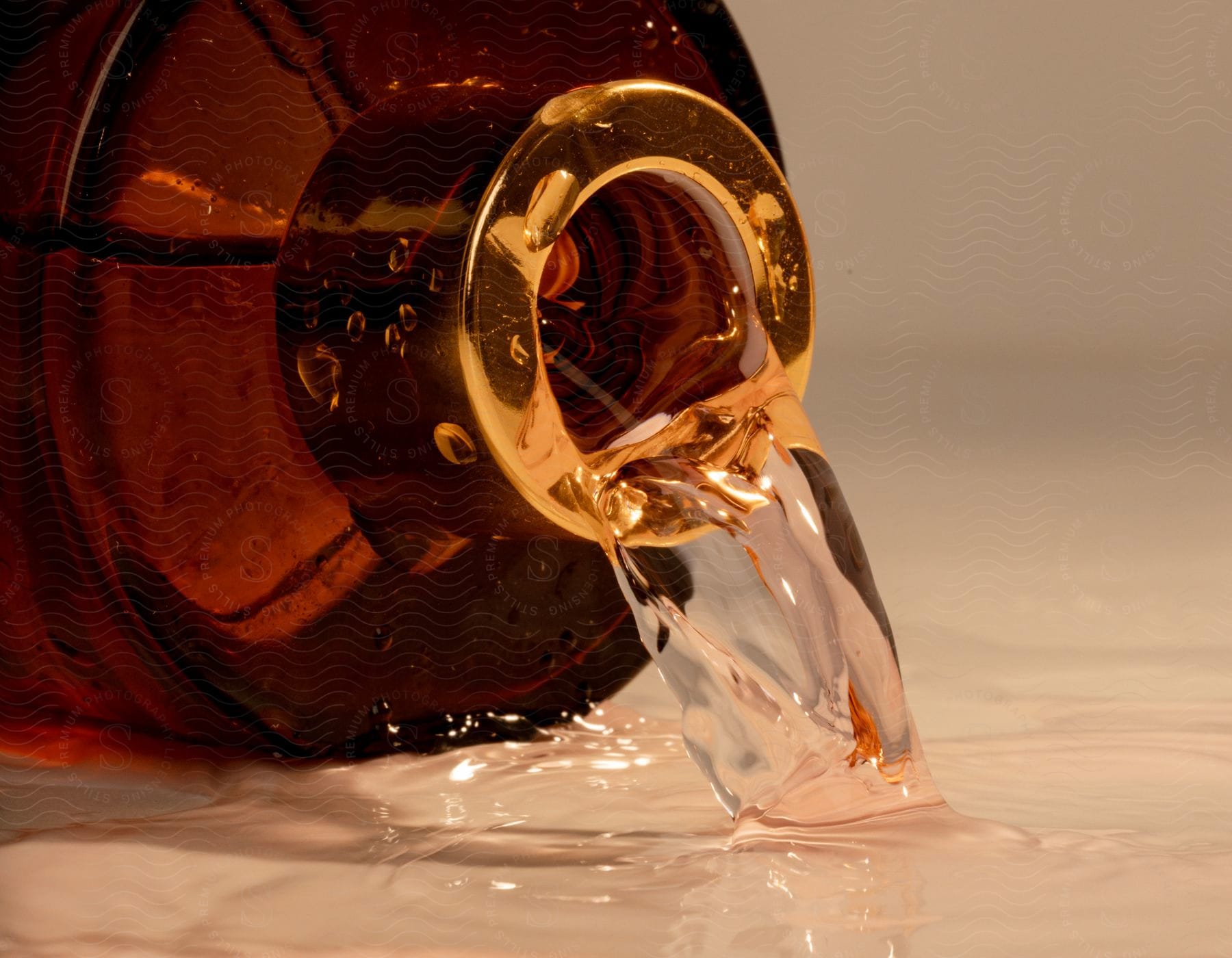 Liquid spills from a glass bottle on the floor