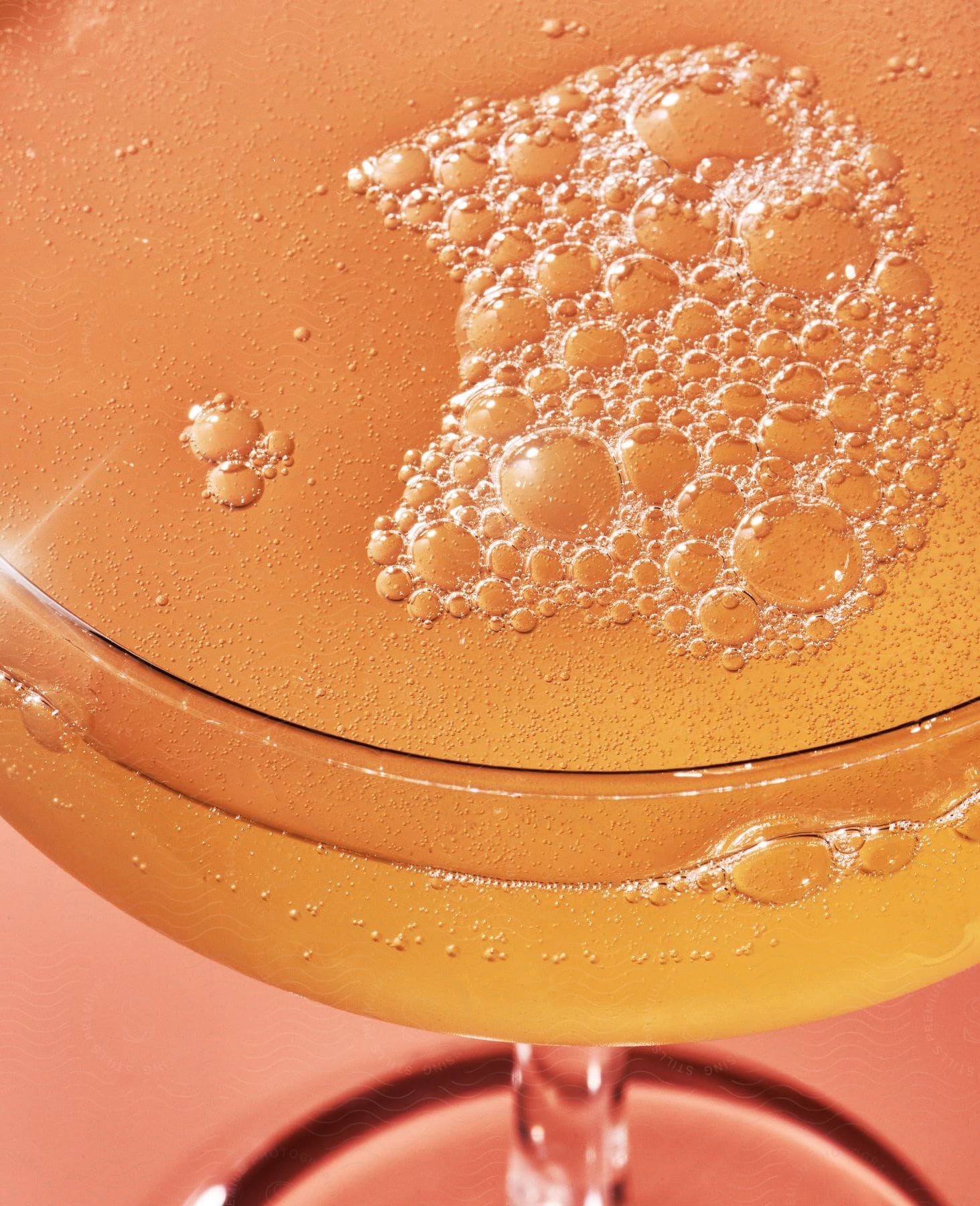 A glass of beverage with bubbles on top