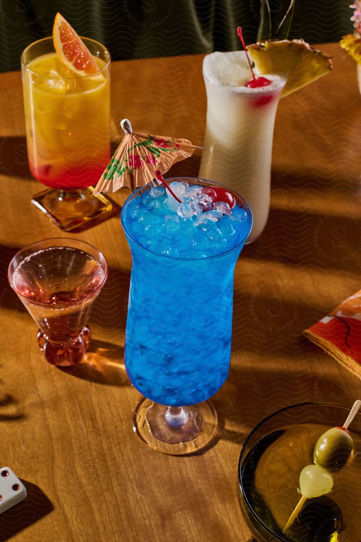 Stock photo of several cocktails and frozen drinks on a brown wood table.