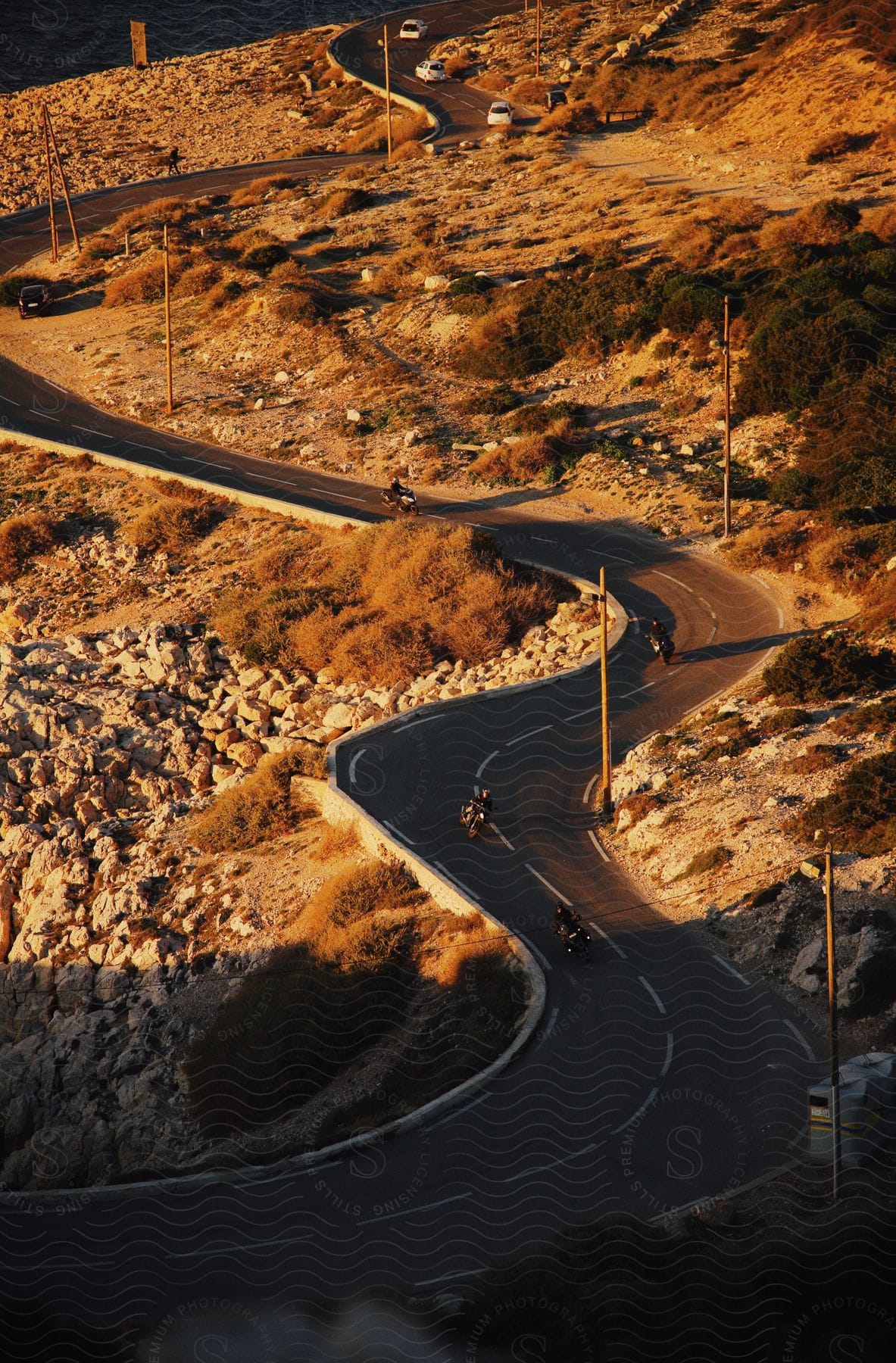 An aerial view of a group of bikers riding motorcycles on a winding road.