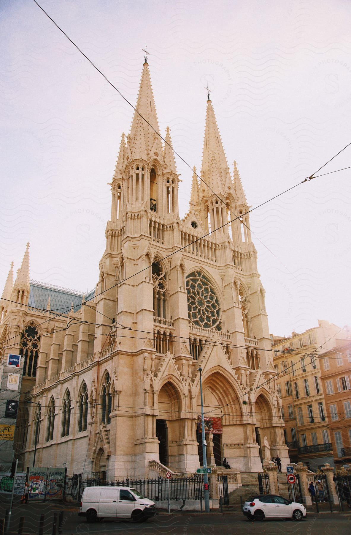 Gothic architecture of St Peter's Cathedral with light traffic on the street