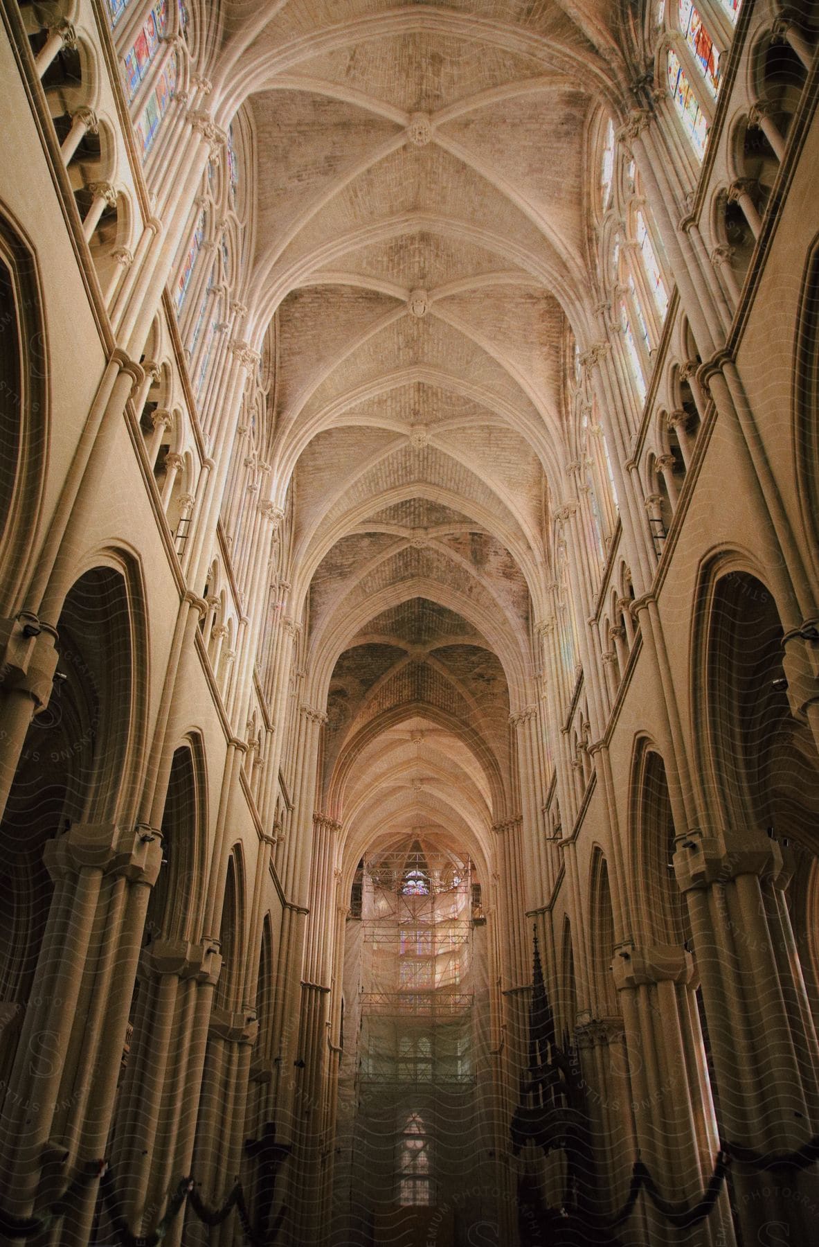 The interior of an old building with several supporting pillars and a very high ceiling.