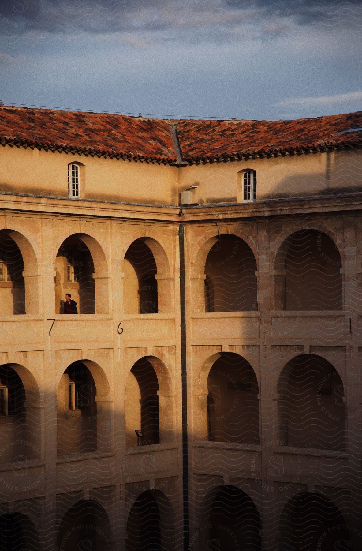 repeated arched openings in multi story building with red tile roof