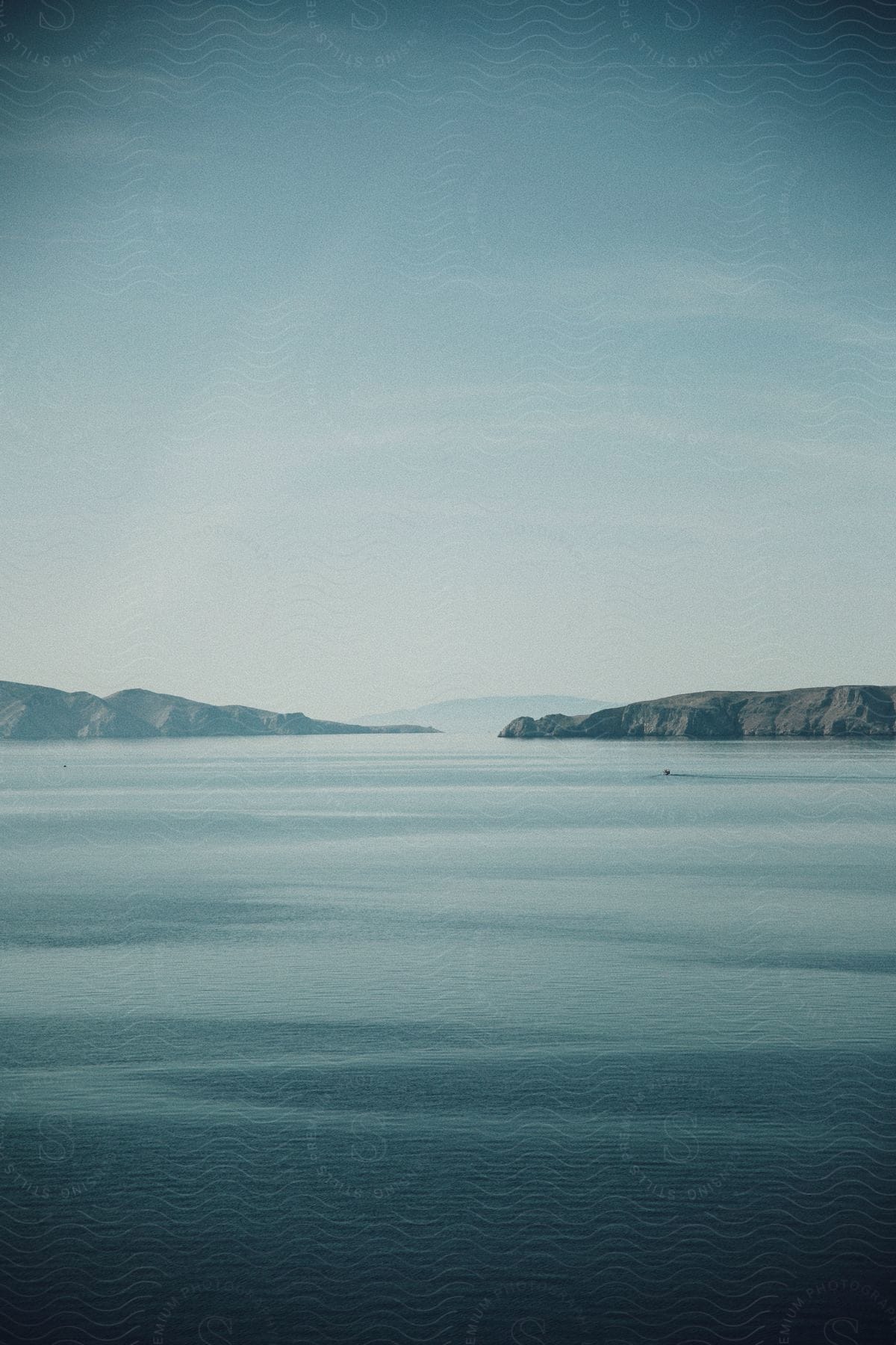 A landscape of serene water with distant coasts in the background.