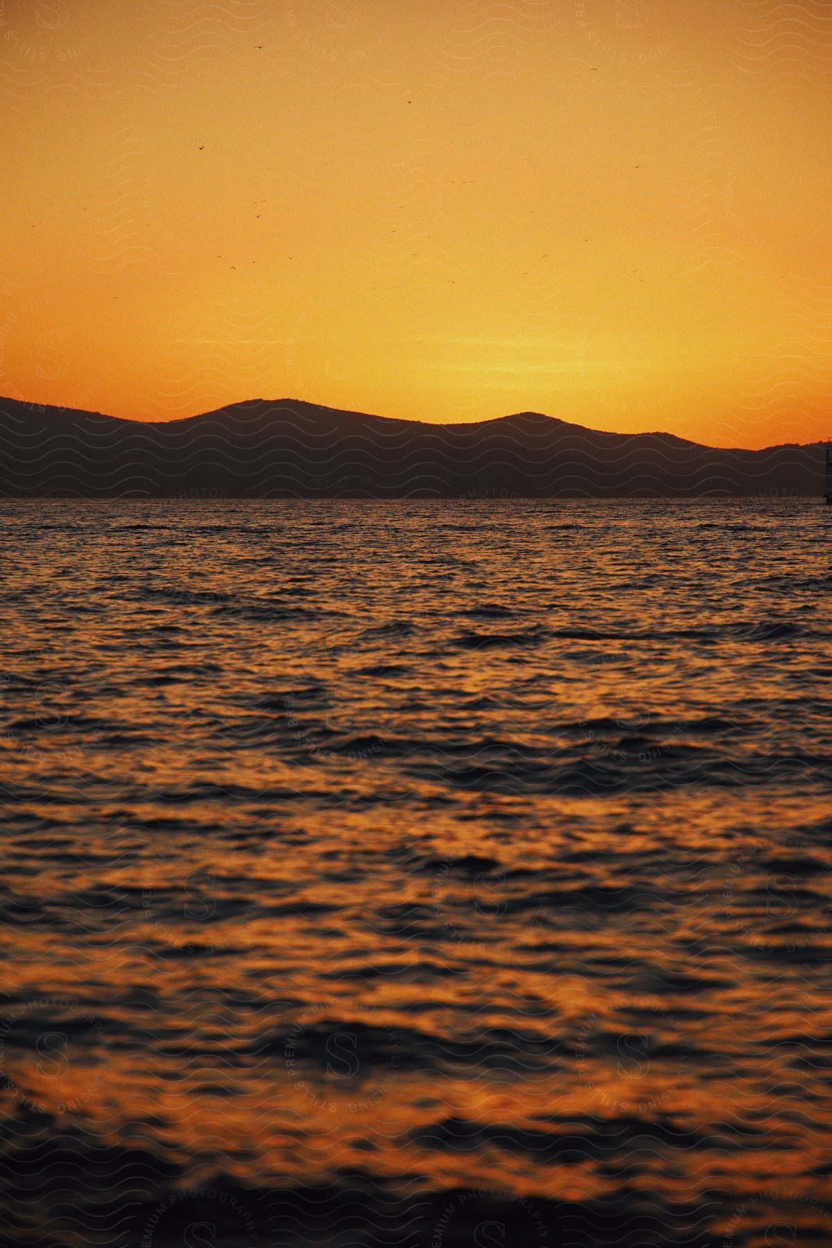 a body of water with mountains in the background.