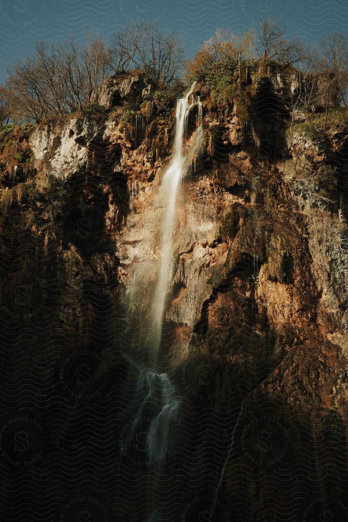 Waterfall cascades down rocky cliff